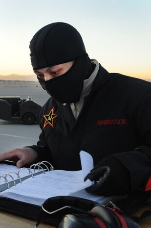 U.S. Air Force Staff Sgt. Rattanak Nhok, 757th Aircraft Maintenance Squadron aircraft armament systems craftsman, checks operating manuals during the quarterly weapons load competition Jan. 6, 2012, at Nellis Air Force Base, Nev. Weapons load competitions are conducted quarterly to keep Airmen sharp and recognize superior performers. Weapons load teams are evaluated for use of the checklist, safety, and overall speed. (U.S. Air Force photo by Staff Sgt. William P.Coleman/Released)  