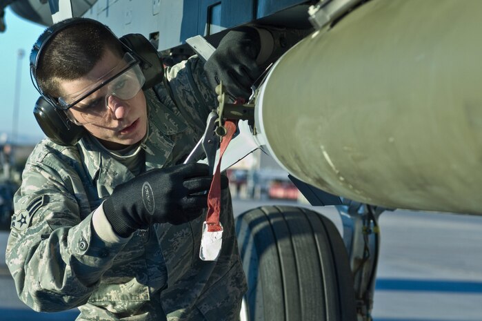 U.S Air Force Airman 1st Class David Mennen, 757th Aircraft Maintenance Squadron weapons load crew member, loads a Mk-82 general purpose bomb onto F15E Strike Eagle during the quarterly weapons load competition Jan. 6, 2012, at Nellis Air Force Base, Nev. Weapons load competitions are conducted quarterly to keep Airmen sharp and recognize superior performers. Weapons load teams are evaluated for use of the checklist, safety, and overall speed.   (U.S. Air Force photo by Airman 1st Class Matthew Lancaster/Released)