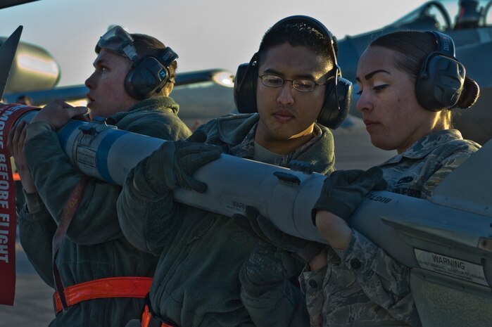 U.S Air Force Senior Airman William Smith , Staff Sgt. Jason Spears and Airman 1st Class Amanda Schreckengost, 57th Aircraft Maintenance Squadron load crew members, load an Air Intercept Missile- 9M Sidewinder onto a F-16 Fighting Falcon during the quarterly weapons load competition Jan. 6, 2012, at Nellis Air Force Base, Nev. Weapons load competitions are conducted quarterly to keep Airmen sharp and recognize superior performers. Weapons load teams are evaluated for use of the checklist, safety, and overall speed.   (U.S. Air Force photo by Airman 1st Class Matthew Lancaster/Released)