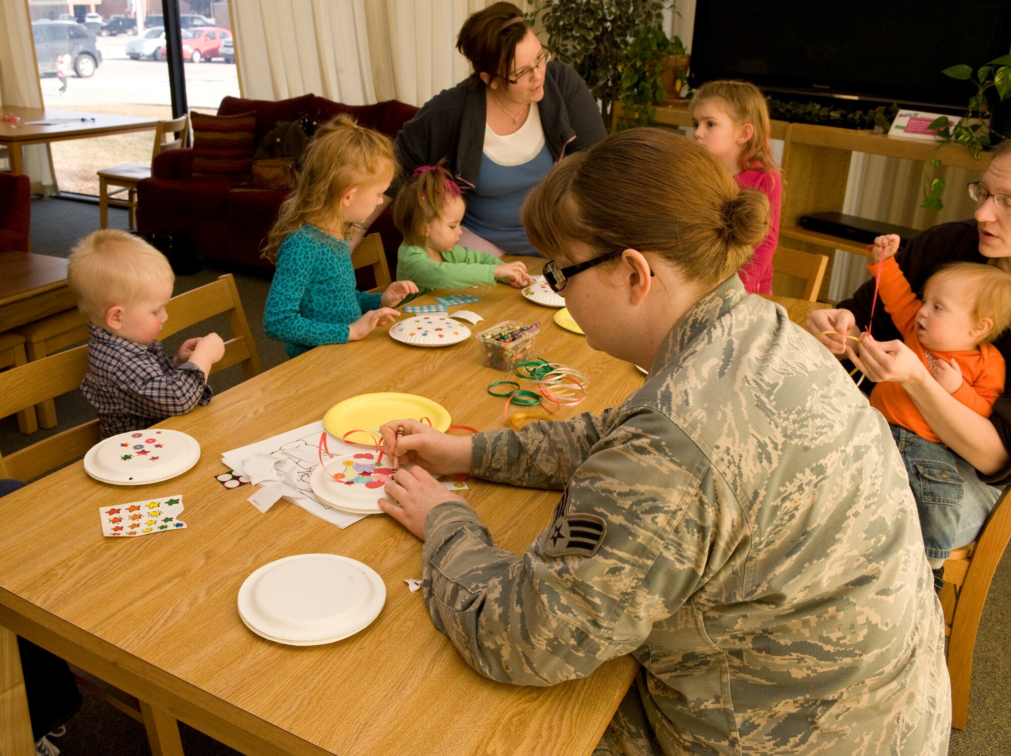 Senior Airman Mindi Bollig, 28th Force Support Squadron services journeyman, participates in arts and crafts with children during Little Warriors Story Time at the Holbrook Library on Ellsworth Air Force Base, S.D., Jan. 5, 2012. Due to the closure of the dining facility on base, Bollig now works temporarily as a librarian. (U.S. Air Force photo by Airman 1st Class Anania Tekurio/released)