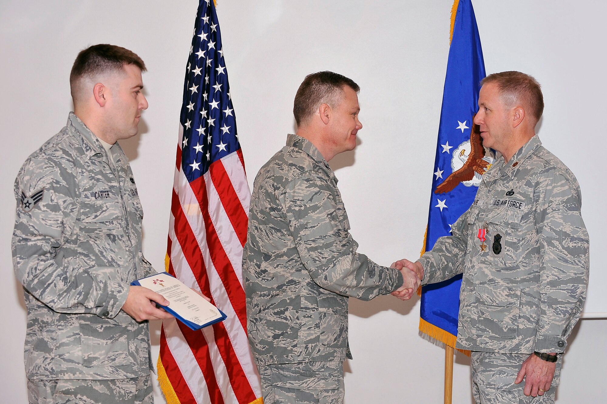 Col. Tim Gibson congratulates Maj. Brent McGuire on receiving a Bronze Star Medal during a presentation ceremony at the Air Force Academy Jan. 6, 2012. McGuire, a reservist working as a civilian with the 10th Security Forces Squadron, received the medal for his actions as commander of the 451st Expeditionary Security Forces Squadron at Kandahar Air Field, Afghanistan. Gibson is the 10th Air Base Wing commander. (U.S. Air Force photo/Elizabeth Andrews)