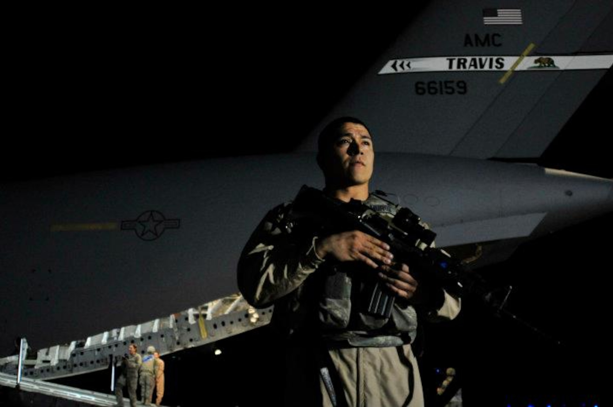 Staff Sgt. Gerardo Munoz guards a C-17 Globemaster III that transported the last combat Airmen from Iraq Dec. 18, 2011, at Ali Air Base, Iraq. The C-17 was a Travis jet and was led by a Travis crew. (U.S. Air Force photo/ Master Sgt. Cecilio Ricardo)