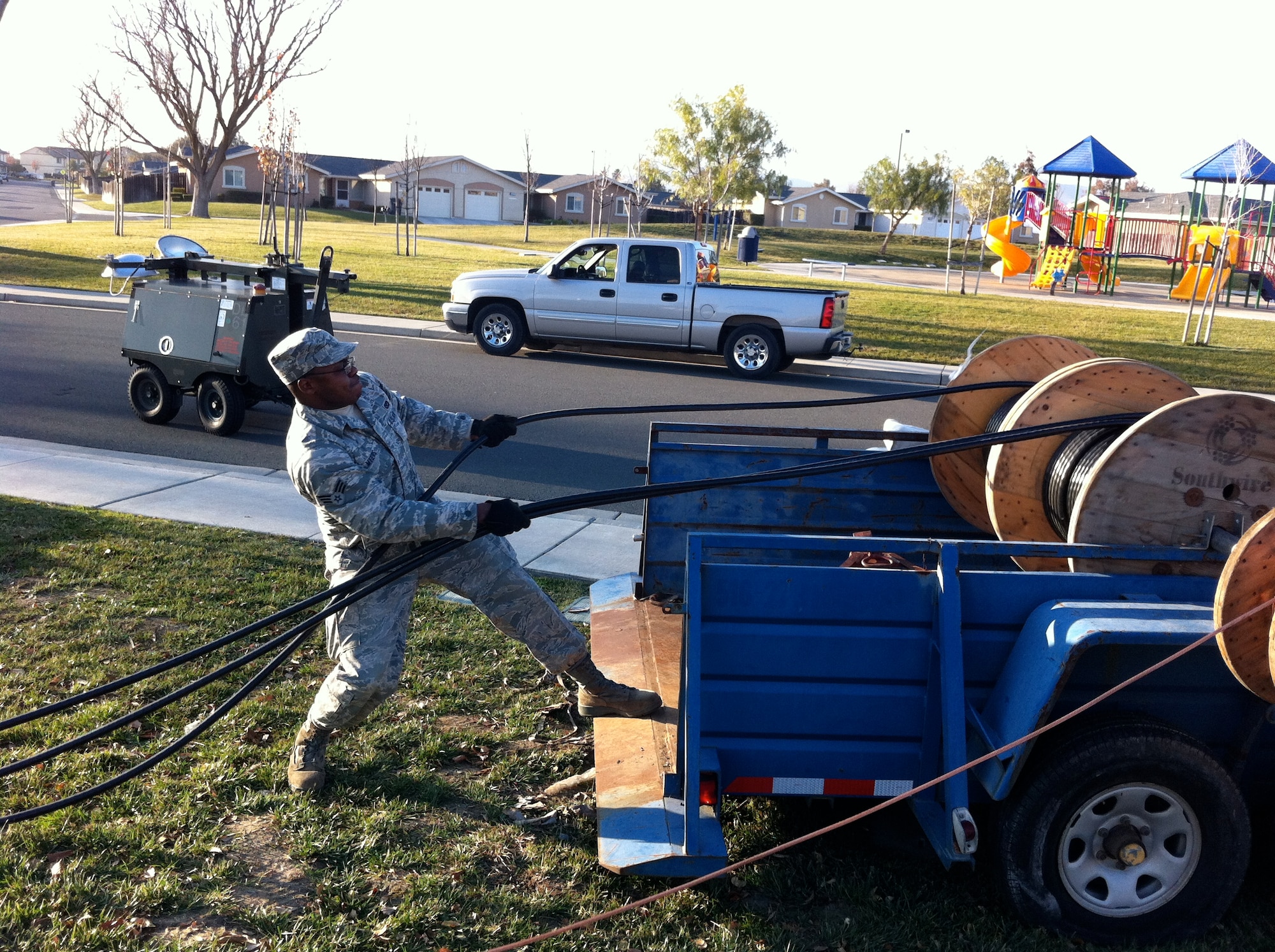 Senior Airman Brandon Myers, 60th Civil Engineer Squadron, pulls high-voltage cable from reels Dec. 24 to make the repair to the high-voltage line which was the cause of a wide-spread power outage at Travis.