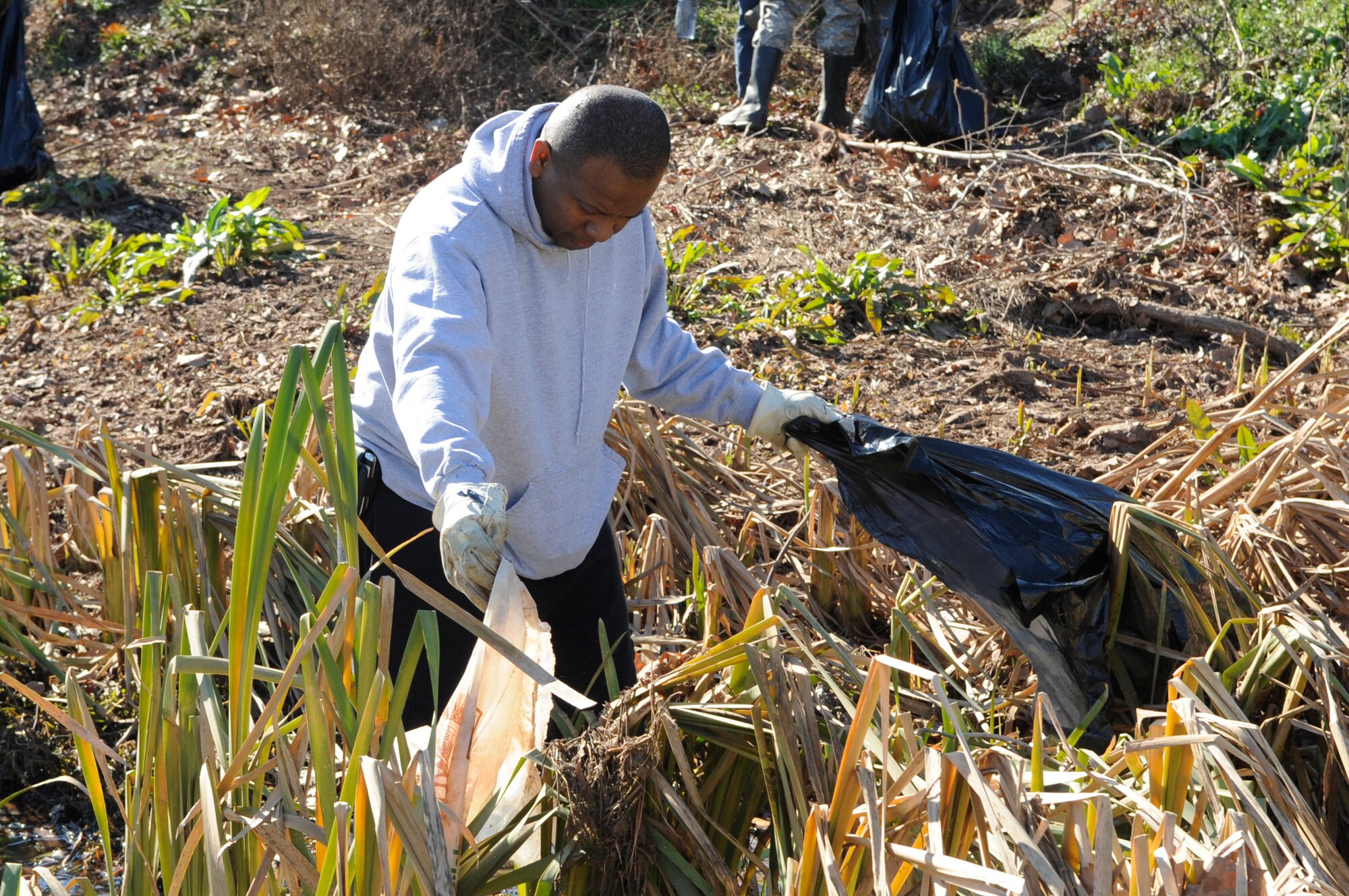 Master Sgt. Emmit Bartee, 2nd Communications Squadron first sergeant, picks up trash along a levee which runs along the north perimeter of Barksdale Air Force Base, La., Jan. 3. Several squadrons teamed up to ensure Barksdale looks its finest for the Installation Excellence Award Team scheduled to arrive on base Jan. 9. Debris gets occasionally washed into the levee due to heavy rains and flooding. The levees are cleaned annually when water levels are low and the debris is visible. (U.S. Air Force photo/Airman 1st Class Andrea F. Liechti)(RELEASED)