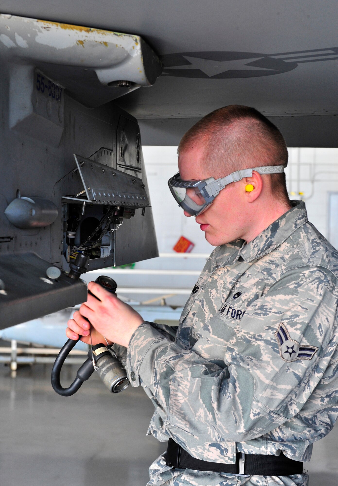 U.S. Air Force Airman 1st Class Timothy Romer, 55th Aircraft Maintenance Unit weapons load member, prepares  an F-16 Fighting Falcon for munitions loading Jan. 6, 2012, Shaw Air Force Base, S.C. The 55th, 77th and 79th Aircraft Maintenance Units Weapons load crews competed against each other in a race against time. All of the load crews were tasked to load three F-16s with weapons within 35 minutes. (U.S. Air Force photo by Senior Airman Amber E. N. Jacobs/Released) 
