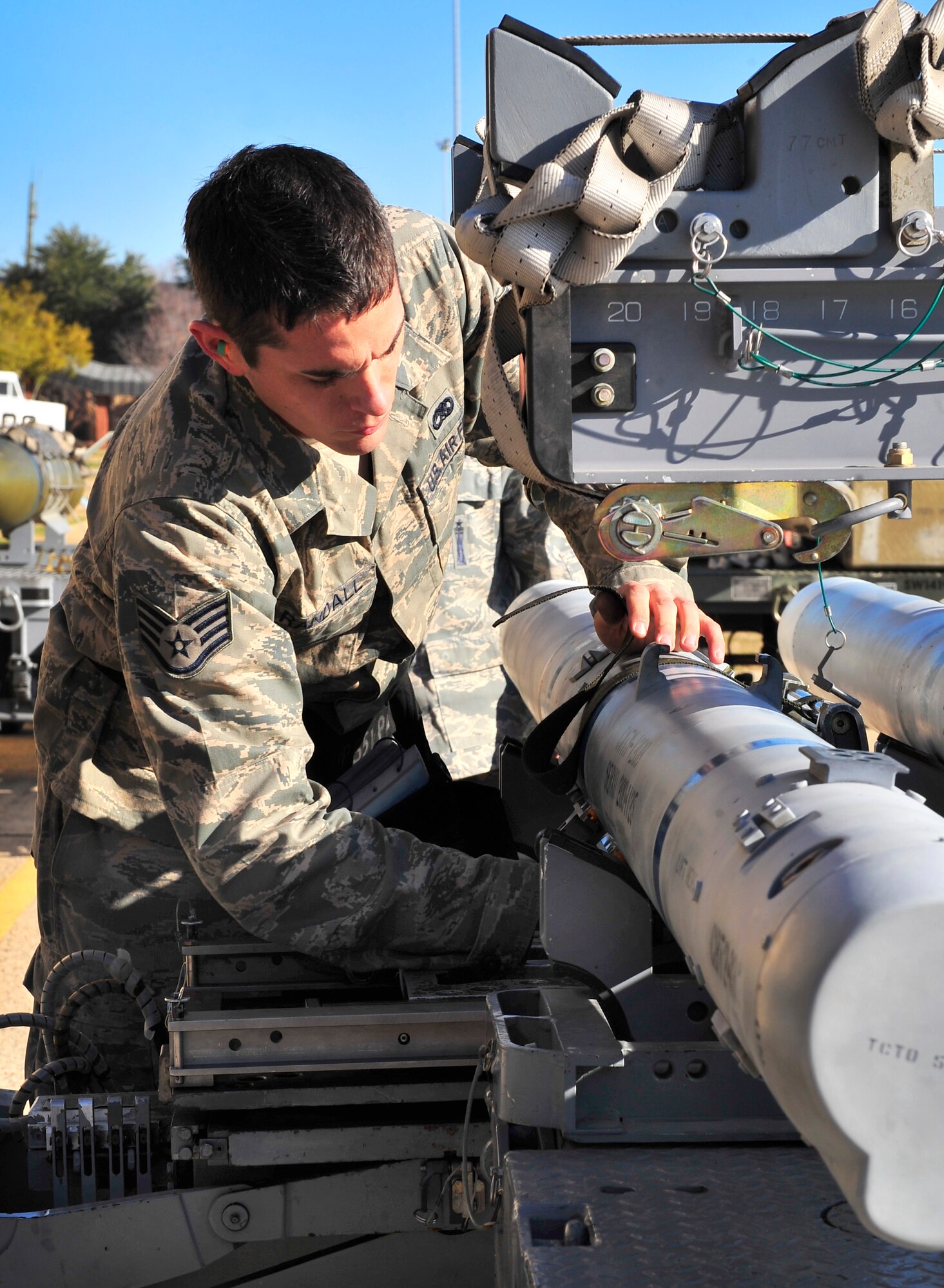 U.S. Air Force Staff Sgt. Richard Randall, 55th Aircraft Maintenance Unit weapons load member, secures an air intercept missile (AIM-120) so it can be moved on Jan. 6, 2012, Shaw Air Force Base, S.C. The 20th Fighter Wing weapons standardization unit held their Weapons Load Crew of the Quarter competition, which brings together weapons load crew members from all three fighter squadrons at Shaw to compete against each other to show who is the best. (U.S. Air Force photo by Senior Airman Amber E. N. Jacobs/Released)
