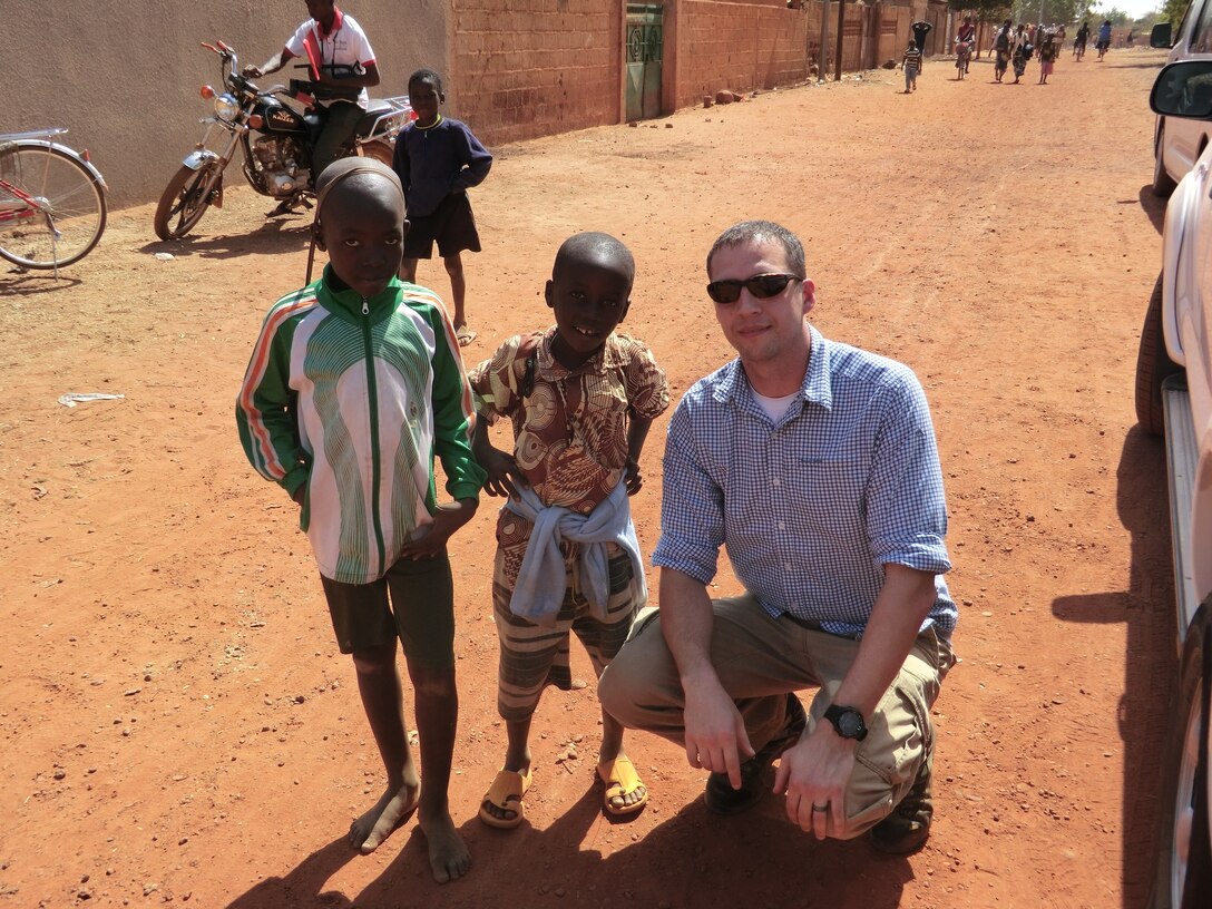 AFOSI Special Agent Derek Wright visits with some local children during a holiday celebration he attended in Kaya, Burkina Faso. He and another OSI agent prepared 40 wrapped gifts to distribute among some of the local students. Burkino Faso is located in Western Africa. (U.S. Air Force Photo)