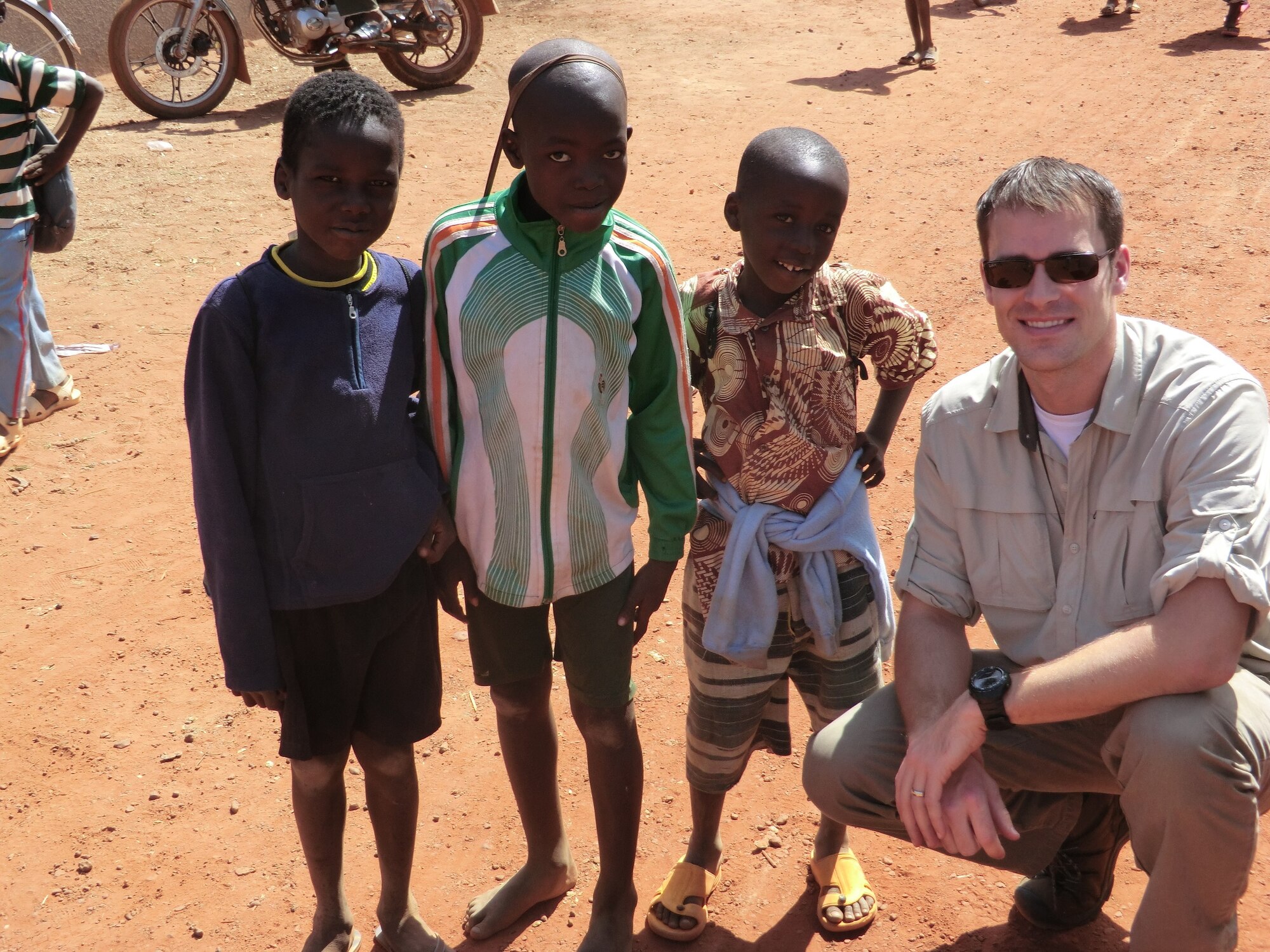 AFOSI Special Agent John Wisocky visits with some local children during a holiday celebration he attended in Kaya, Burkina Faso. He and another OSI agent prepared 40 wrapped gifts to distribute among some of the local students. Burkino Faso is located in Western Africa. (U.S. Air Force Photo)