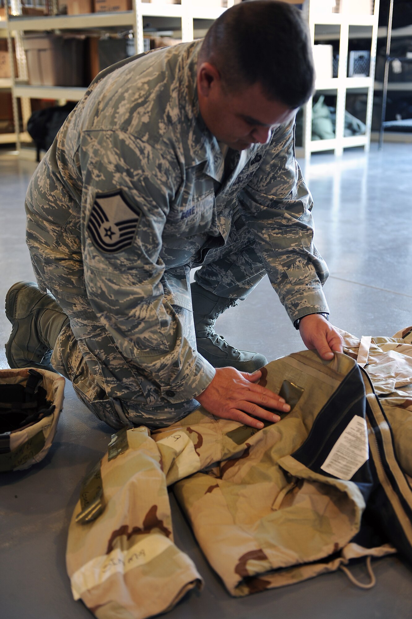 U.S. Air Force Master Sgt. Mark Gore, 23rd Force Support Squadron first sergeant, places identification tapes during ability to survive and operate training at Moody Air Force Base, Ga., Jan. 5, 2012. Identification tapes are placed on personal protection equipment such as helmets, gas mask carriers and chemical protective over garments for personnel recognition. (U.S. Air Force photo by Staff Sgt. Ciara Wymbs/Released)  
