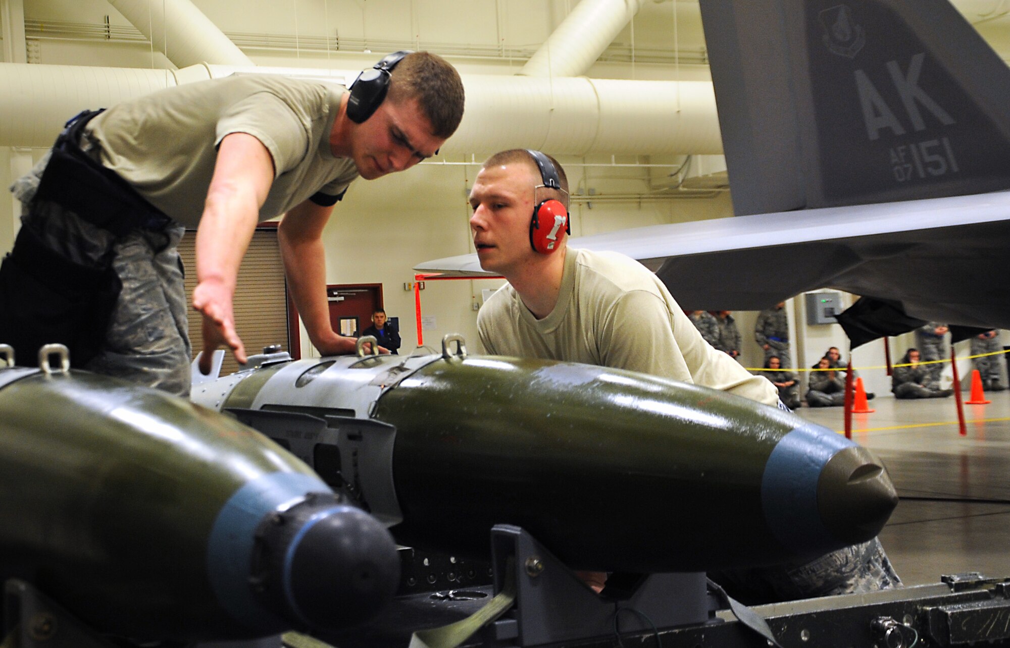 JOINT BASE ELMENDORF-RICHARDSON, Alaska --Staff Sgt. Roger Roscoe, right, and Senior Airman Damian Herbert work together during the weapons load crew of the year competition Dec. 14. Three teams competed for the annual award after winning a quarterly competition. Roscoe and Herbert are both aircraft armament systems specialist with the 525th Aircraft Maintenance Unit. (U.S. Air Force photo/Staff Sgt. Cynthia Spalding) 
