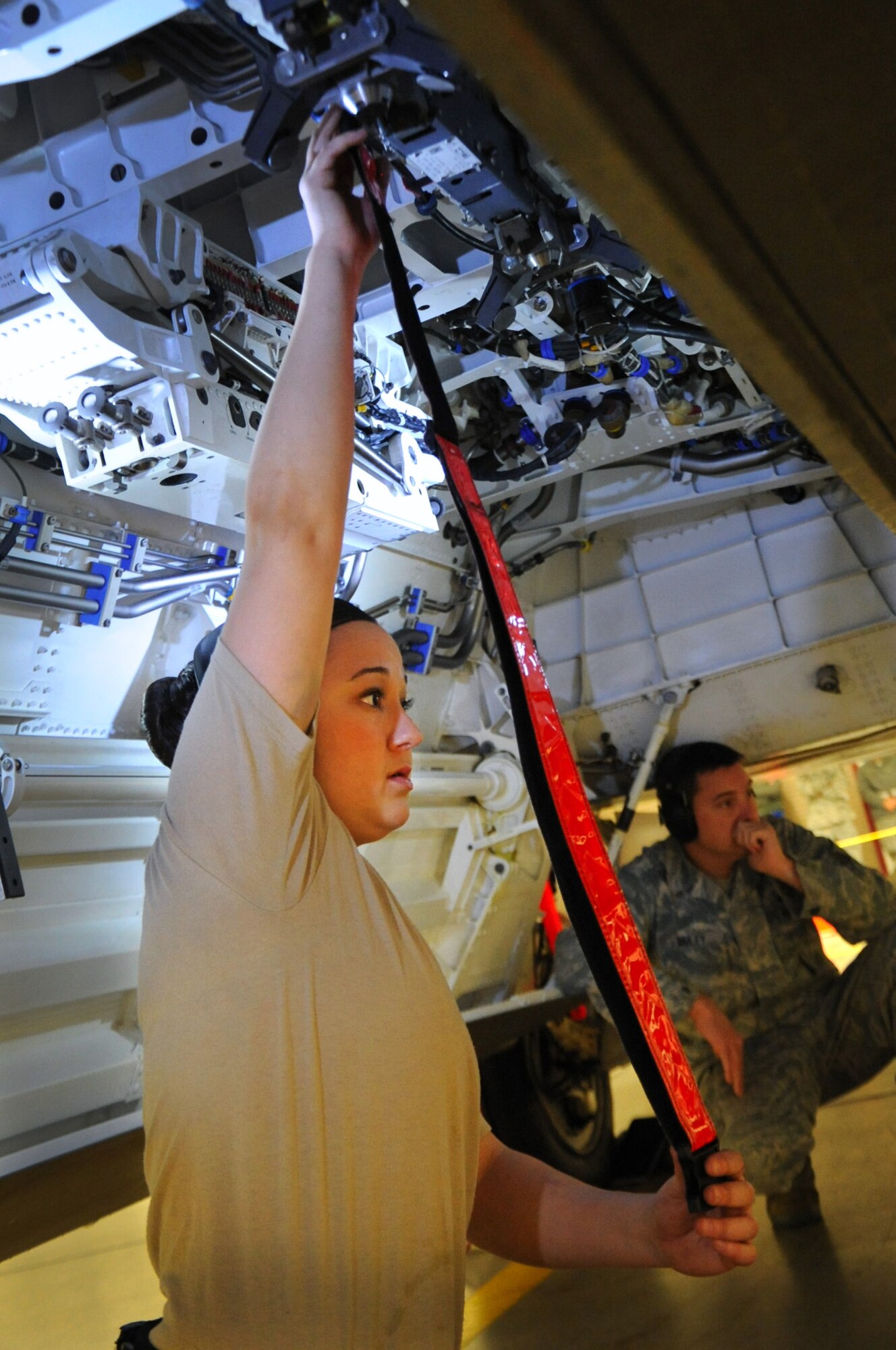 JOINT BASE ELMENDORF-RICHARDSON, Alaska -- Senior Airman Colleen McMillian holds a reflective belt as a guide for loading a joint direct attack munition during a quarterly load competition Dec. 9. Her crew went on to compete for the annual award Dec. 14. McMillian is an aircraft armament systems specialist with the 90th Aircraft Maintenance Unit. (U.S. Air Force photo/Staff Sgt. Cynthia Spalding)