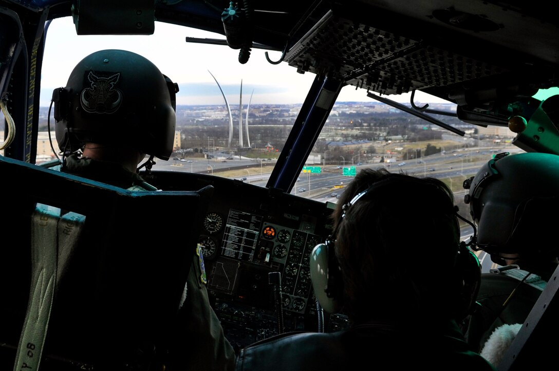 A UH-1N Iroquois helicopter from the 1st Helicopter Squadron here glides between the U.S. Air Force Memorial and Pentagon Dec. 29 in Arlington, VA. The UH-1N is a light-lift utility helicopter used to support varied Air Force missions. Its primary function includes airlift of emergency security and disaster response forces, the emergency evacuation of key government officials, and airlift of distinguished visitors and missile support personnel. (U.S. Air Force Photo/Senior Airman Perry Aston)