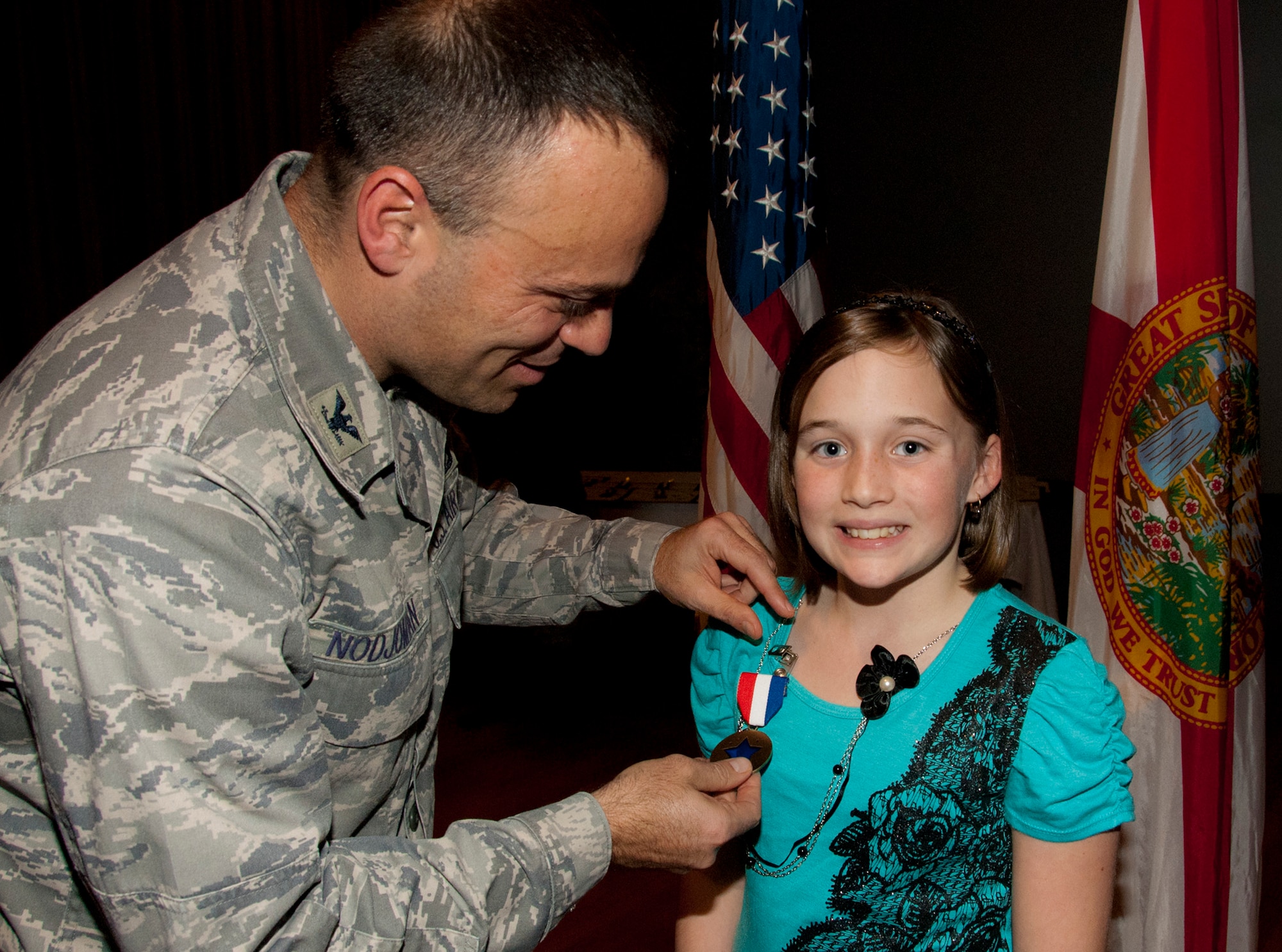 Col. Sal Nodjomian, the 96th Air Base Wing commander, pins a “Home Front Hero” blue star medal on Nayan Harper Jan. 5.  The Home Front Hero award recognizes children for their contributions to their parents’ successes in the military.  (U.S. Air Force photo/Kevin Gaddie)