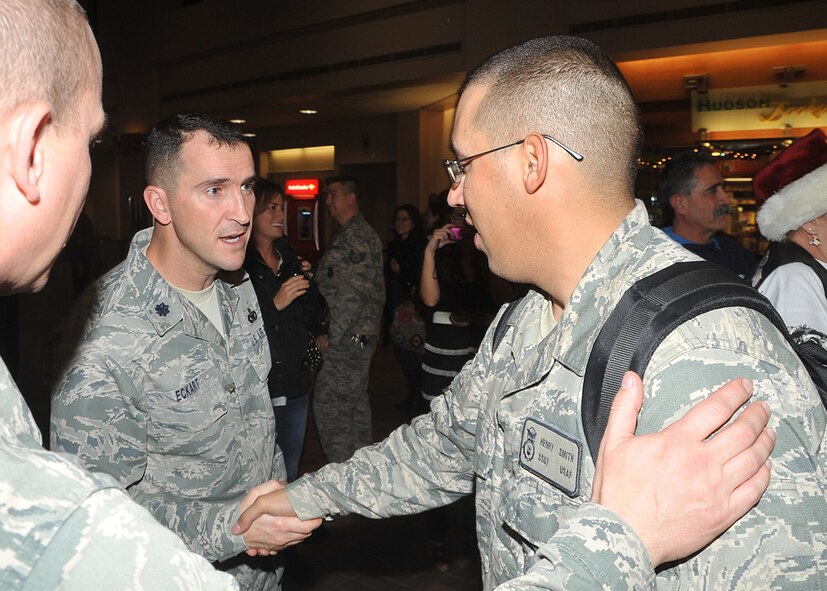 Lt. Col. Bryan Eckart, 377th Weapons System Security Squadron commander, shakes the hand of Staff Sgt. Henry Smith on Jan. 1 at the Albuquerque Sunport following Smith’s return from Afghanistan.  U.S. Air Force Photo by Todd Berenger