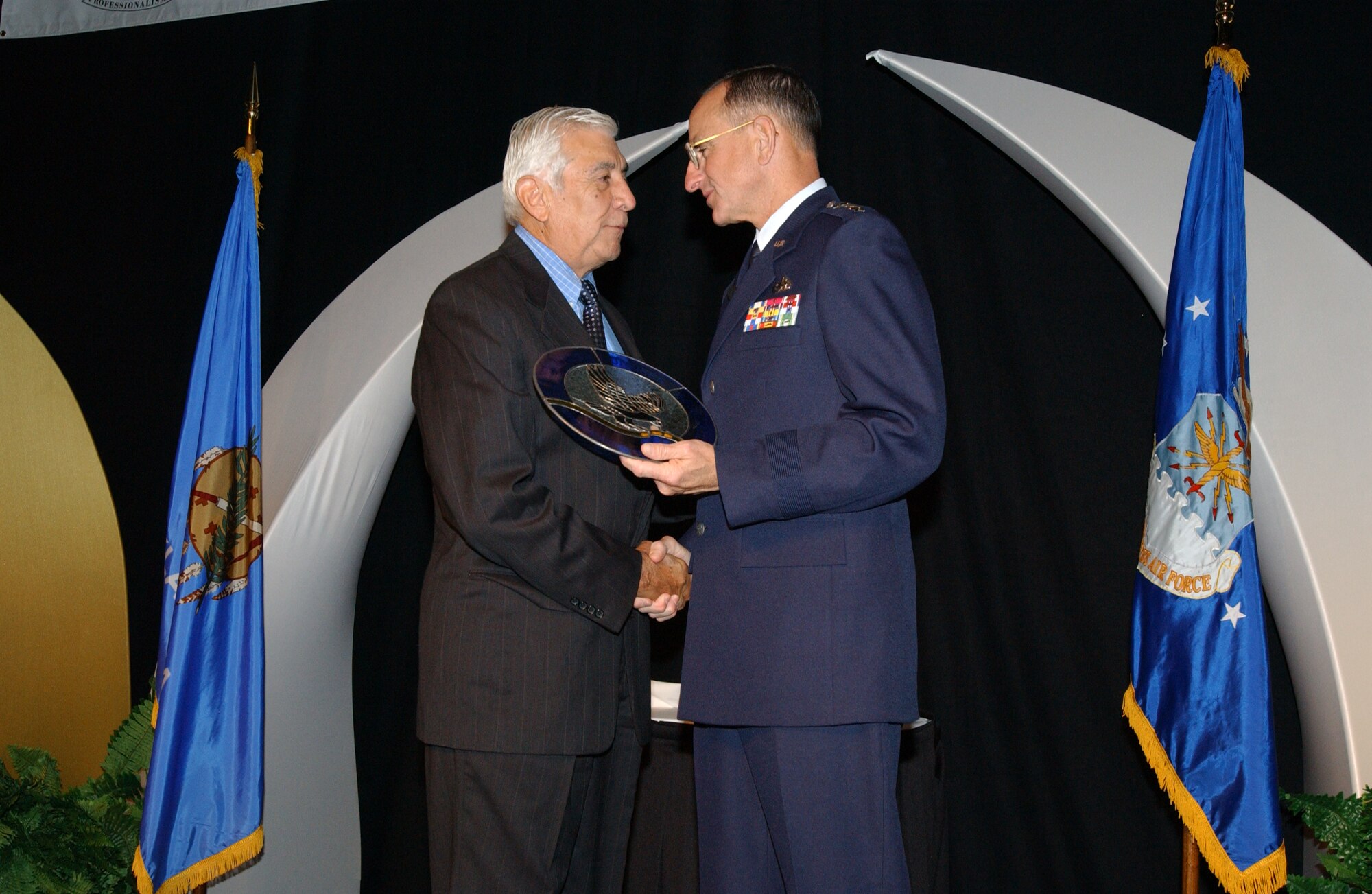 Retired Lt. Gen. Michael E. Zettler, right, presents the Logistics Officer Association Lifetime Achievement Award to retired Lt. Gen. Leo Marquez at the 2003 LOA conference. 