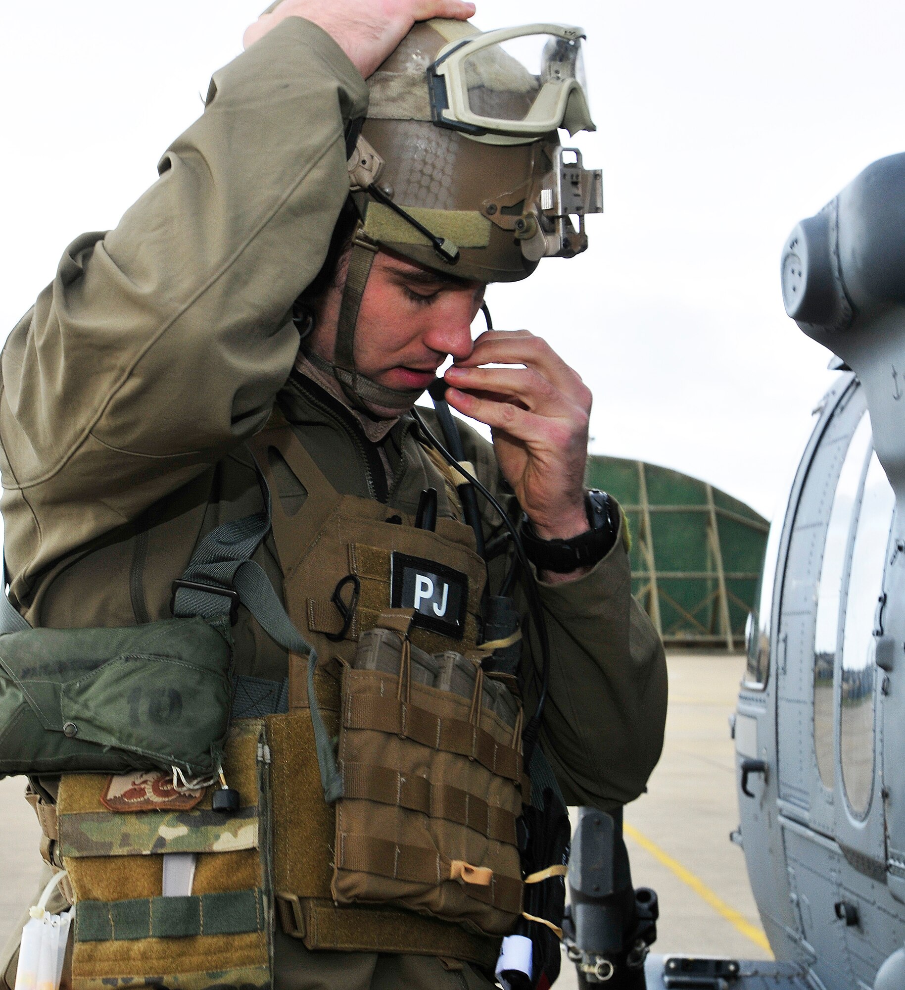 ROYAL AIR FORCE LAKENHEATH, England - Senior Airman Cody Cerny, 56th Rescue Squadron pararescueman, adjusts his microphone on the flightline prior to taking off in an HH-60G Pave Hawk Jan. 5, 2012. While on alert with the 212th Rescue Squadron in Alaska, Cerny responded to an urgent medical evacuation request and saved the life of a utility worker on Dec. 16, 2011. The worker had fallen down a steep slope and sustained injuries to his chest. (U.S. Air Force photo by Senior Airman Tiffany M. Deuel)