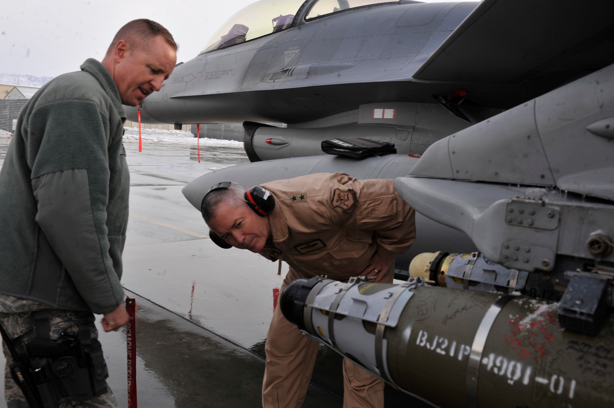 BAGRAM AIRFIELD, Afghanistan—Col. Geoffrey Bacon discusses a part of the F-16 aircraft weaponry with Maj. Gen. William H. Etter at Bagram Airfield, Afghanistan, Jan. 6, 2012. Bacon is the 455th Expeditionary Maintenance Group commander and Etter is the deputy director of the Air National Guard. Bacon is deployed from Stuttgart Germany, United States European Command, and  Etter is visiting from the Pentagon in Washington D.C.  . (U.S. Air Force photo/ Airman 1st Class Ericka Engblom)