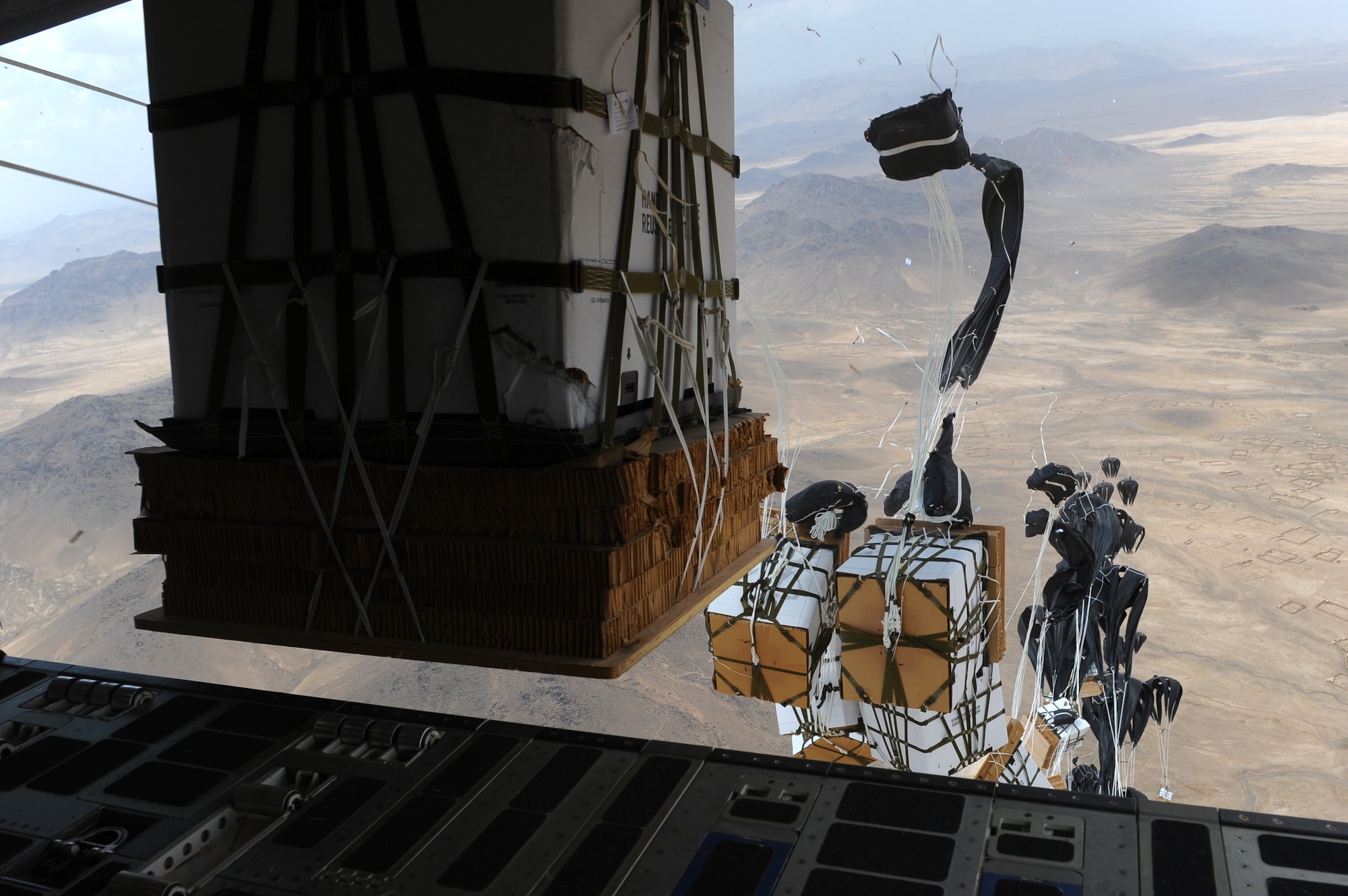 Pallets of water are released from a C-17 Globemaster III aircraft assigned to the 816th Expeditionary Airlift Squadron during an airdrop mission over Afghanistan in support of Operation Enduring Freedom on May 26, 2011. (U.S. Air Force photo/Master Sgt. William Greer)