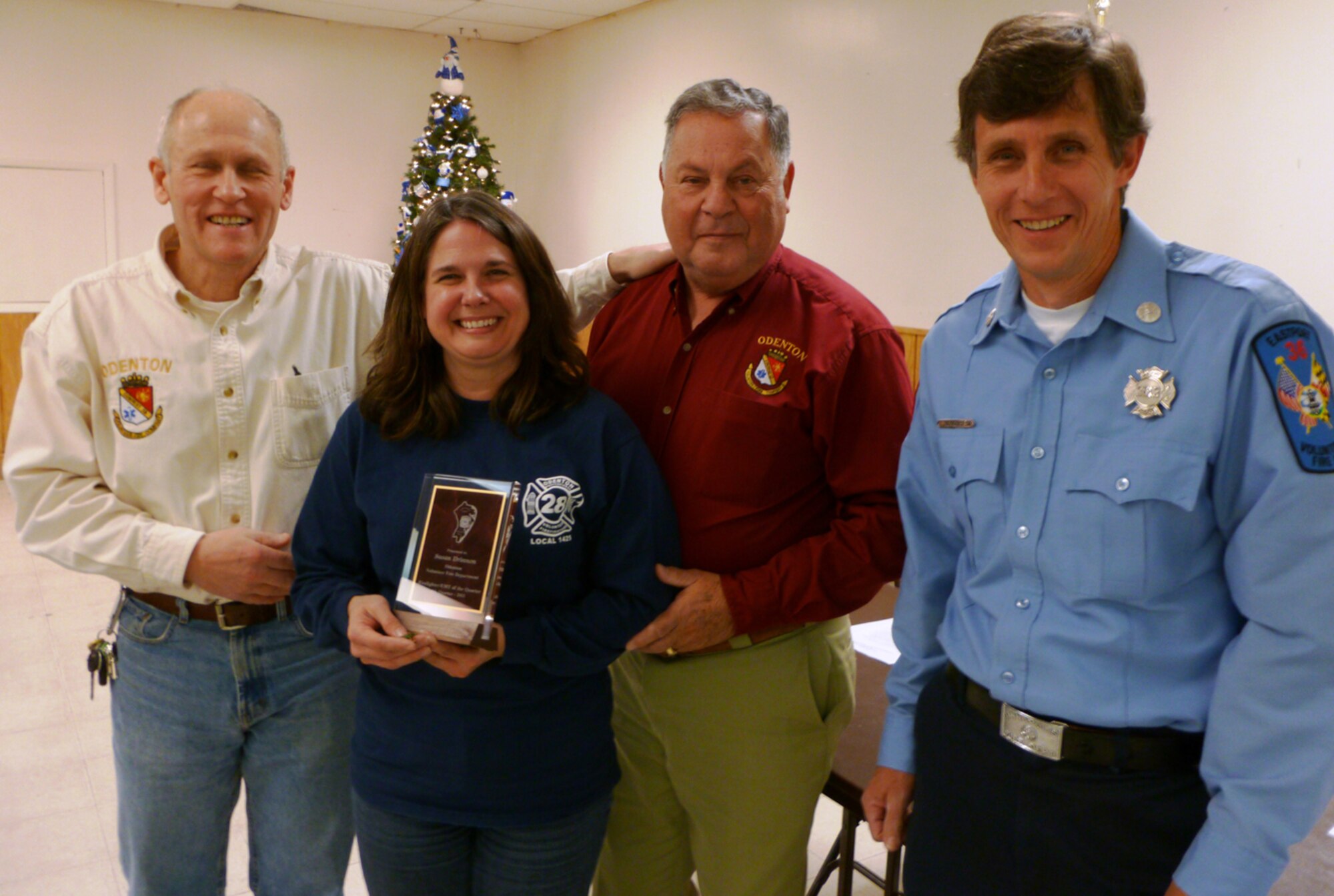 Susan Drinnon, Tunnel 9 computer scientist/system administrator, poses with Odenton Volunteer Fire Company (OVFC) Chief Don Evick (left), OVFC Vice President Wylie Donaldson and Anne Arundel County Volunteer Firefighters Association Award Chair Tom Newquist, when they presented her with the Anne Arundel County Firefighter/EMS/Administrative Member of the Quarter award for her work at the fire station. (Photo provided)