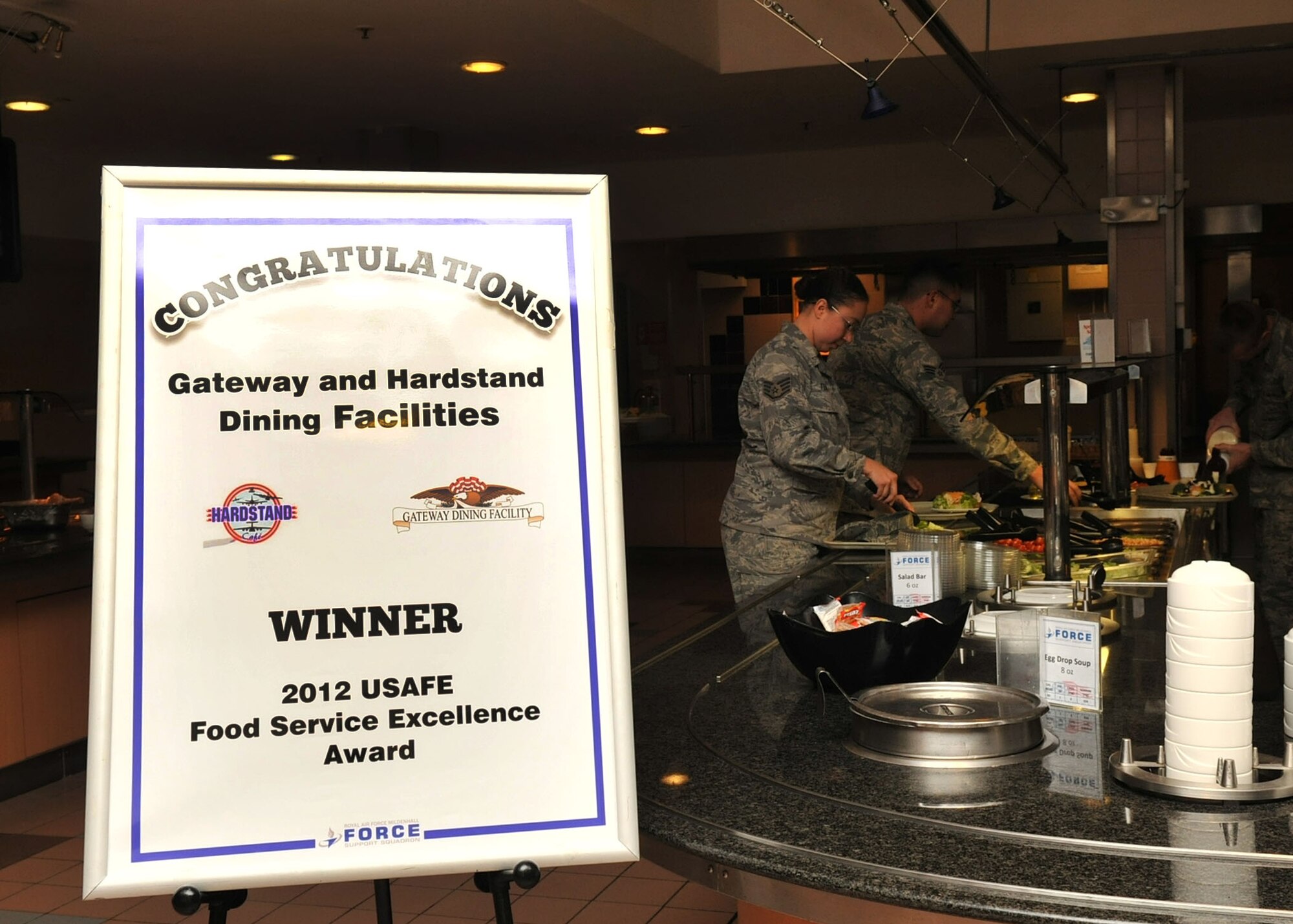 RAF MILDENHALL, England - A sign displayed at the Gateway Dining Facility congratulates the food services flight here Jan 4, 2012. U.S. Air Forces in Europe officials recently named the 100th Air Refueling Wing’s dining facility the overall winner for the 2012 USAFE Food Service Excellence Award in the single facility category. They will represent USAFE and compete for the Air Force Hennessy Award. (U.S. Air Force photo/Senior Airman Jerilyn Quintanilla)