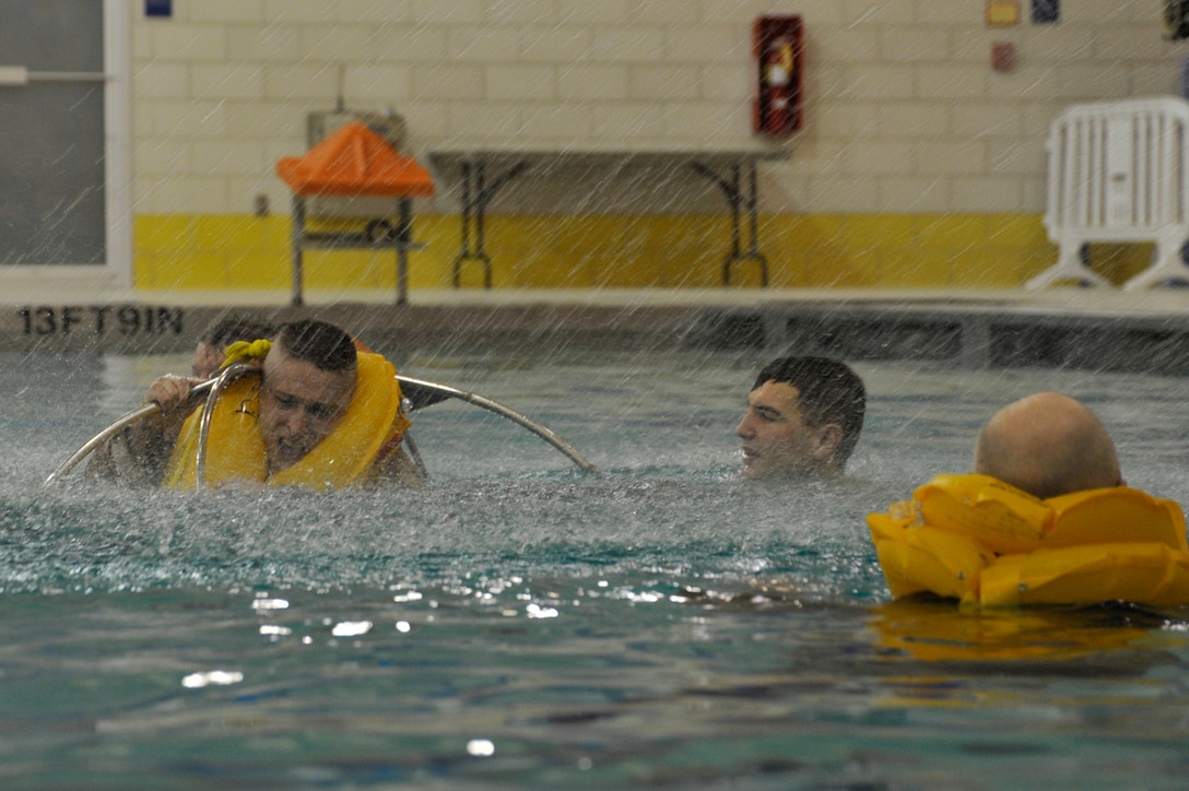 Staff Sgt. Christopher DeJesus, 89th Operations Support Squadron Survival, Evasion, Resistance, Escape specialist, sprays a hose to simulate rough water while S.E.R.E. refresher course students enter a U.S. Coast Guard rescue basket Nov. 17 at the Prince George's Sports & Learning Complex in Landover, Md. The U.S. Coast Guard rescue basket is the standard rescue basket used on all U.S. Coast Guard rescue helicopters. (U.S. Air Force Photo/Senior Airman Perry Aston)


