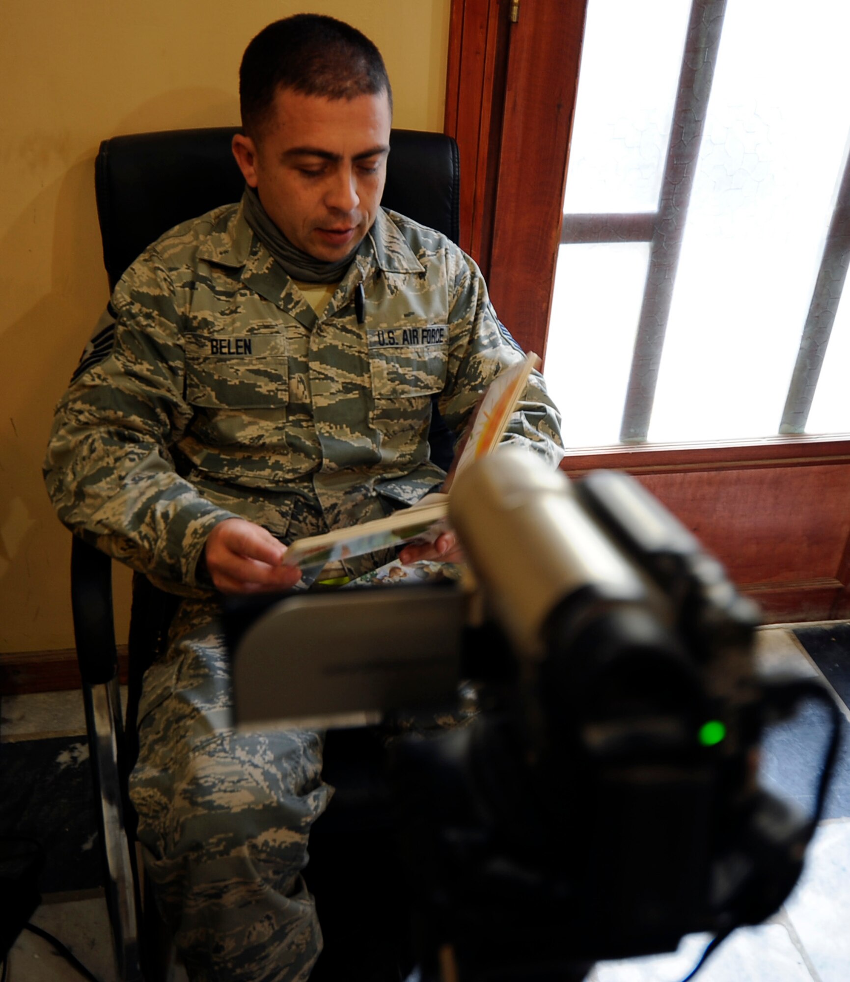 Master Sgt. Santiago Belen reads a children's book in Spanish as he records a story for his children at the United Services Organization in Bagram, Afghanistan, Jan. 2, 2012.  Belen is deployed from the Puerto Rico Air National Guard.  (U.S. Air Force photo/Tech. Sgt. Vernon Cunningham)