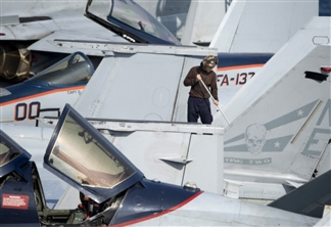 A U.S. Navy sailor cleans an F/A-18F Super Hornet assigned to Strike Fighter Squadron 2 aboard the aircraft carrier USS Abraham Lincoln (CVN 72) in the South China Sea on Jan. 5, 2012.  The Abraham Lincoln is underway in the U.S. 7th Fleet area of responsibility as part of a deployment to the western Pacific and Indian Oceans en route to support coalition efforts in the U.S. 5th Fleet area of responsibility.  