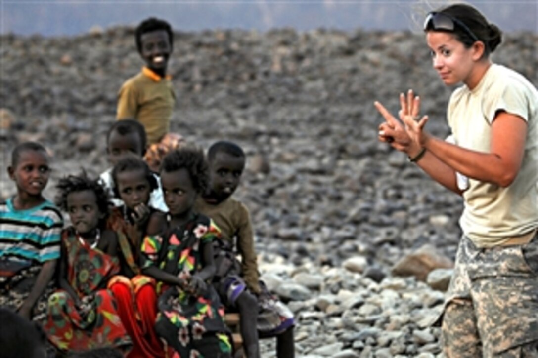 U.S. Army Spc. Tiffany Larriba raises six fingers while playing a game with children during the "Soldier in the Classroom" program at Karabti San, Djibouti, Jan. 3, 2012. Larriba is a team member assigned to the Civil Affairs Team 4902, 490th Civil Affairs Battalion. The program is designed to teach children basic English.