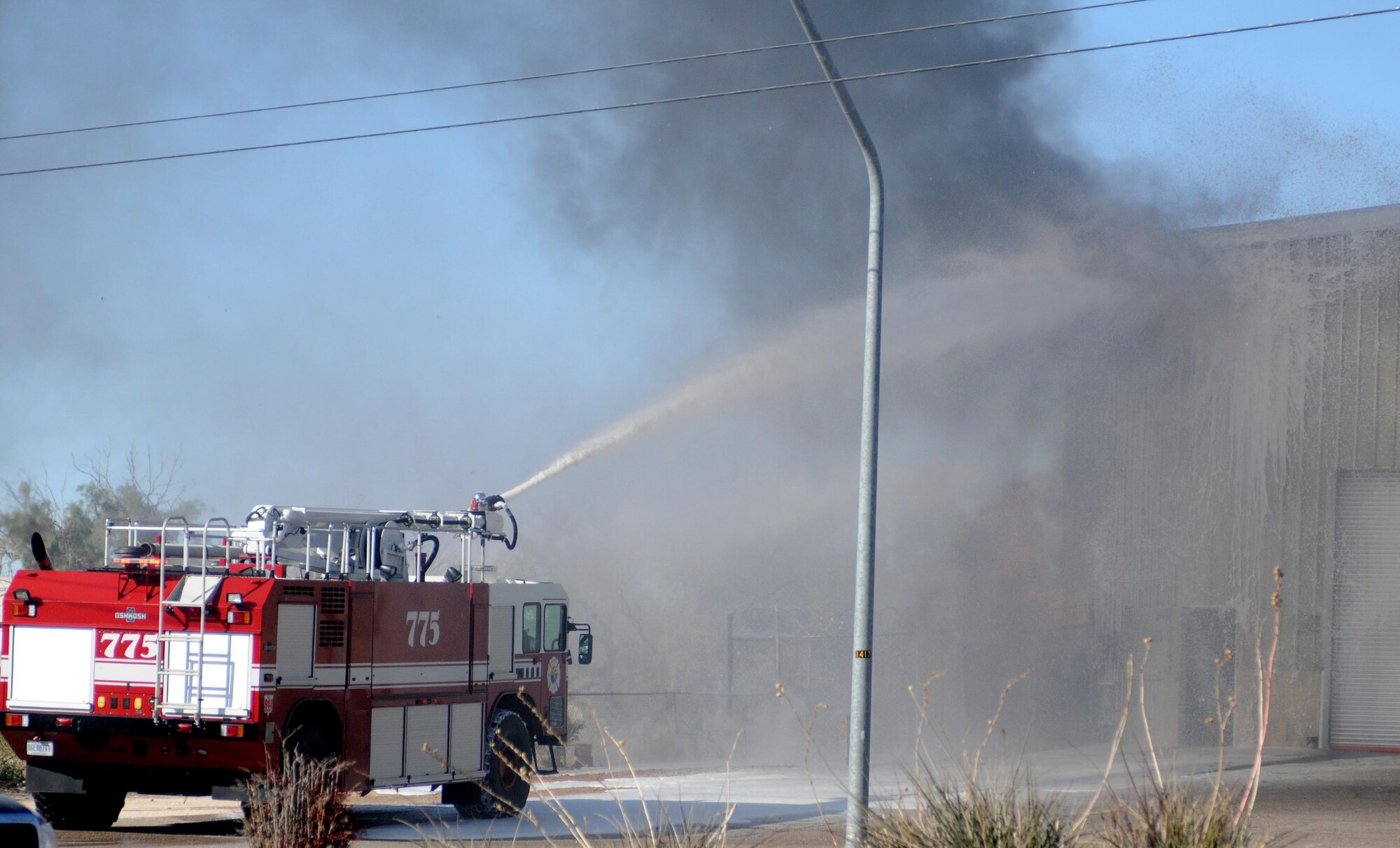 Arizona Air National Guard firefighters extinguish at a fire across the street from their base on Valencia Road with a rescue truck designed to extinguish aircraft fires, Jan. 7. The Airmen assigned to the 162nd Fighter Wing were performing their monthly drill weekend duties when a transformer next to the GE Apparatus Service center exploded.  (U.S. Air Force photo/Maj. Gabe Johnson)