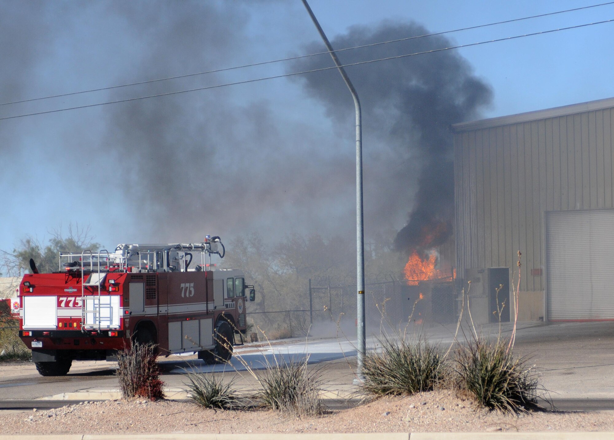 Arizona Air National Guard firefighters arrive at a fire across the street from their base on Valencia Road with a rescue truck designed to extinguish aircraft fires, Jan. 7. The Airmen assigned to the 162nd Fighter Wing were performing their monthly drill weekend duties when a transformer next to the GE Apparatus Service center exploded.  (U.S. Air Force photo/Maj. Gabe Johnson)