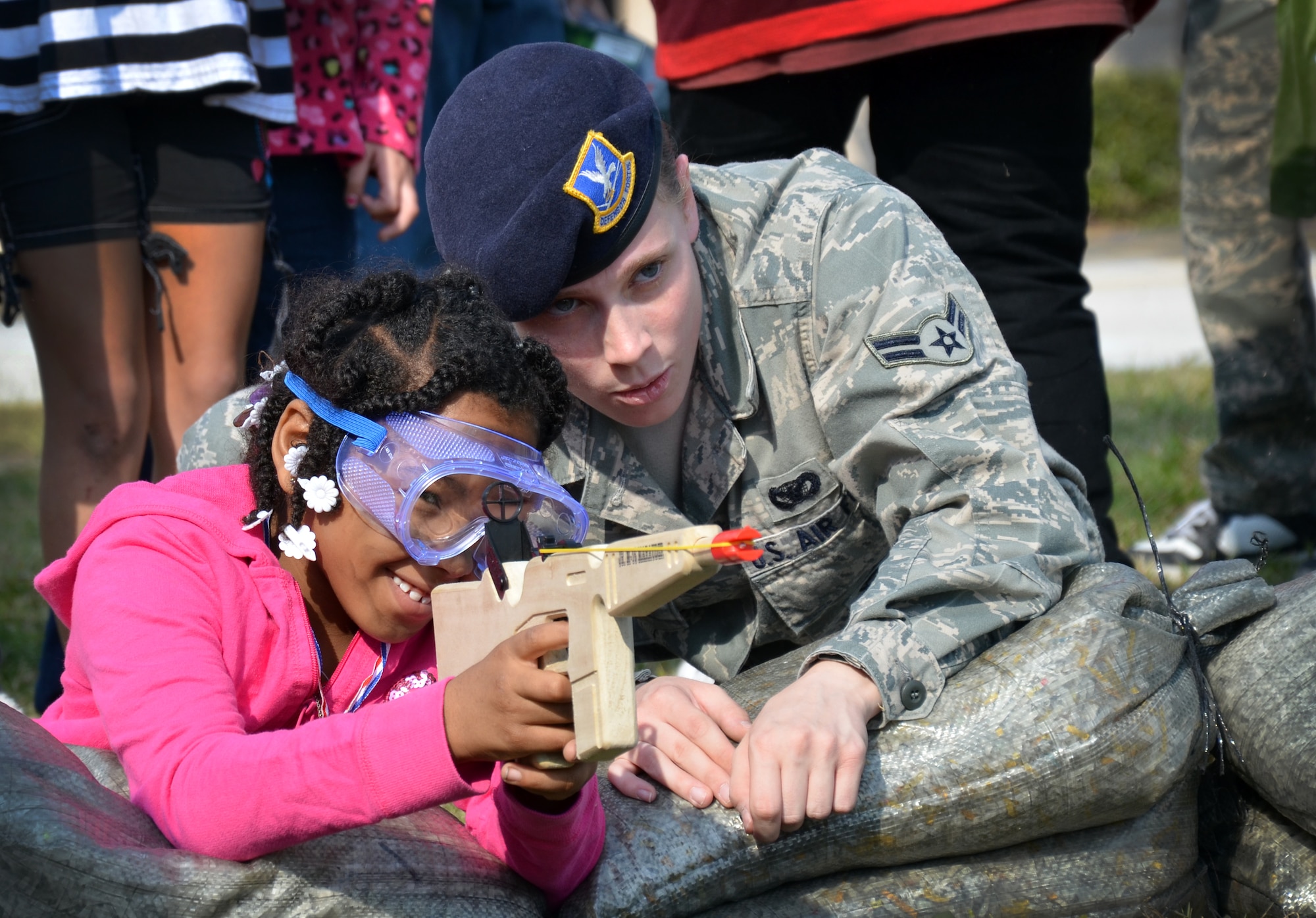 A Security Forces Airman helps a child aim a rubber band gun at a plastic target during the Kids Understanding Deployments event at Patrick Air Force Base, Fla., Jan. 7, 2012. The event was designed to help active-duty and Reserve dependent children learn about the deployment process in a fun, interactive way.  (U.S. Air Force photo/Staff Sgt. Anna-Marie Wyant)