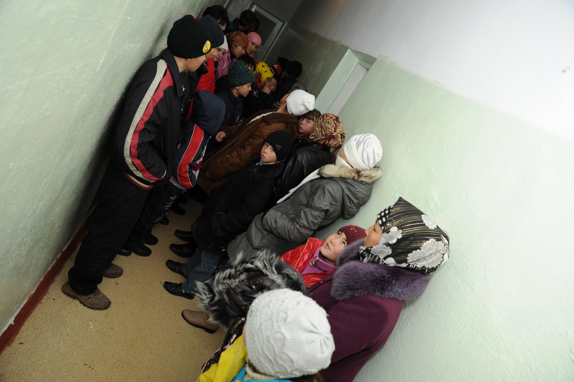 Kyrgyz citizens of Vasilievka Village wait in the hallway of the Vasilievka Elementary School, Jan. 5, 2012, during an Operation Warm and Dry coat distribution, Kyrgyzstan. The coat recipients were identified by Ministry of Social Protection workers with the assistance of Manzura, the school principal. Approximately 160 coats were given out in Vasilievka by volunteers from the Transit Center at Manas. Operation Warm and Dry is a program sponsored and managed by the Theater Security Cooperation division at the TCM.
(U.S. Air Force photo/Master Sgt. Tracy L. DeMarco)
