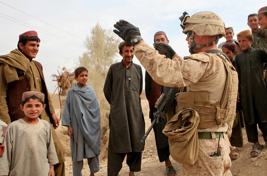 Chief Warrant Officer 2 Brandon Smith, the officer in charge of Heavy Equipment Platoon, Support Company, 7th Engineer Support Battalion, 2nd Marine Logistics Group (Forward), speaks with locals while his unit conducts road repairs in Helmand province, Afghanistan, Nov. 3.  Marines with 7th ESB repaired multiple areas along Route 611 in support of Operation Eastern Storm and after redeploying, 9th ESB continued to make progress on the major thoroughfare. (U.S. Marine Corps photo by Cpl. Katherine M. Solano)