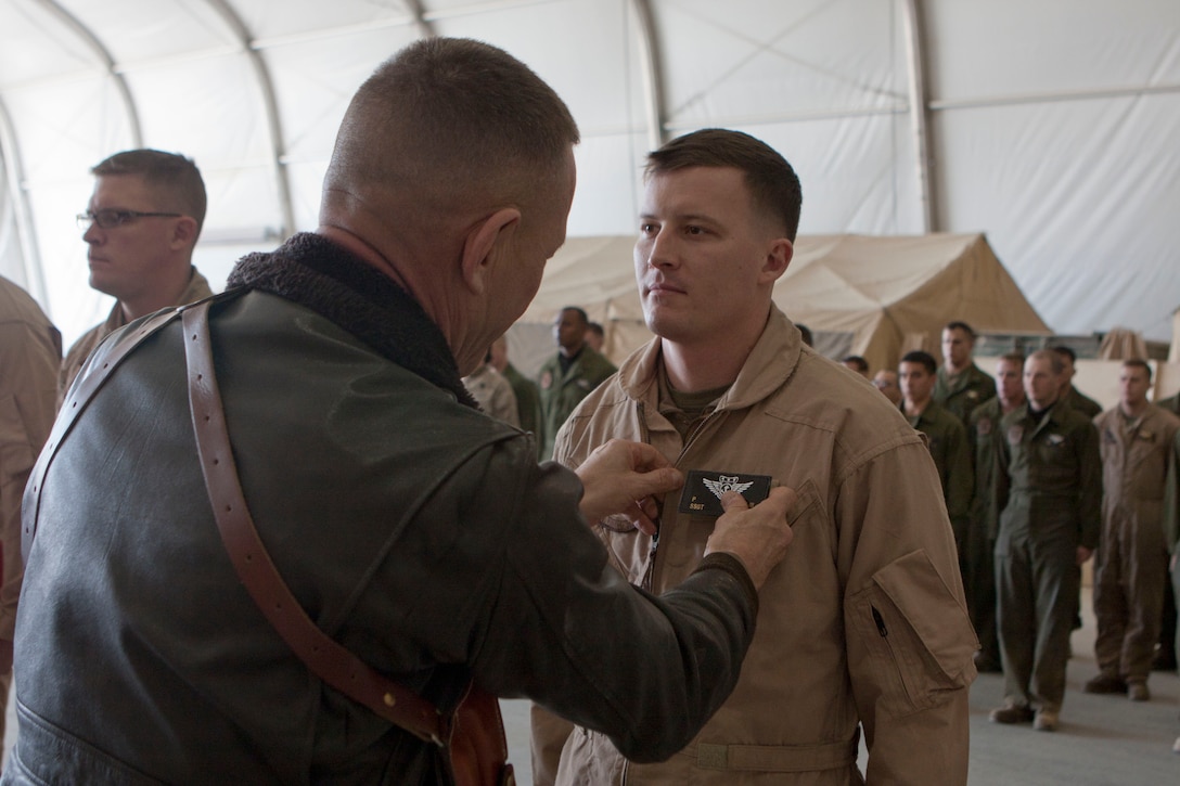 Maj. Gen. Jon M. Davis, left, 2nd Marine Aircraft Wing commanding general, places a combat aircrew wings patch on Staff Sgt. Paul Workman III, a crew chief with Marine Heavy Helicopter Squadron 363, during a ceremony at Camp Bastion, Afghanistan, Jan. 8. Davis visited Camp Bastion to present awards to Marines of HMH-363 in recognition of their performance supporting operations in southwestern Afghanistan with 2nd Marine Aircraft Wing (Forward).::r::::n::To connect with the Marines in Afghanistan visit http://www.facebook.com/regionalcommandsouthwest::r::::n::