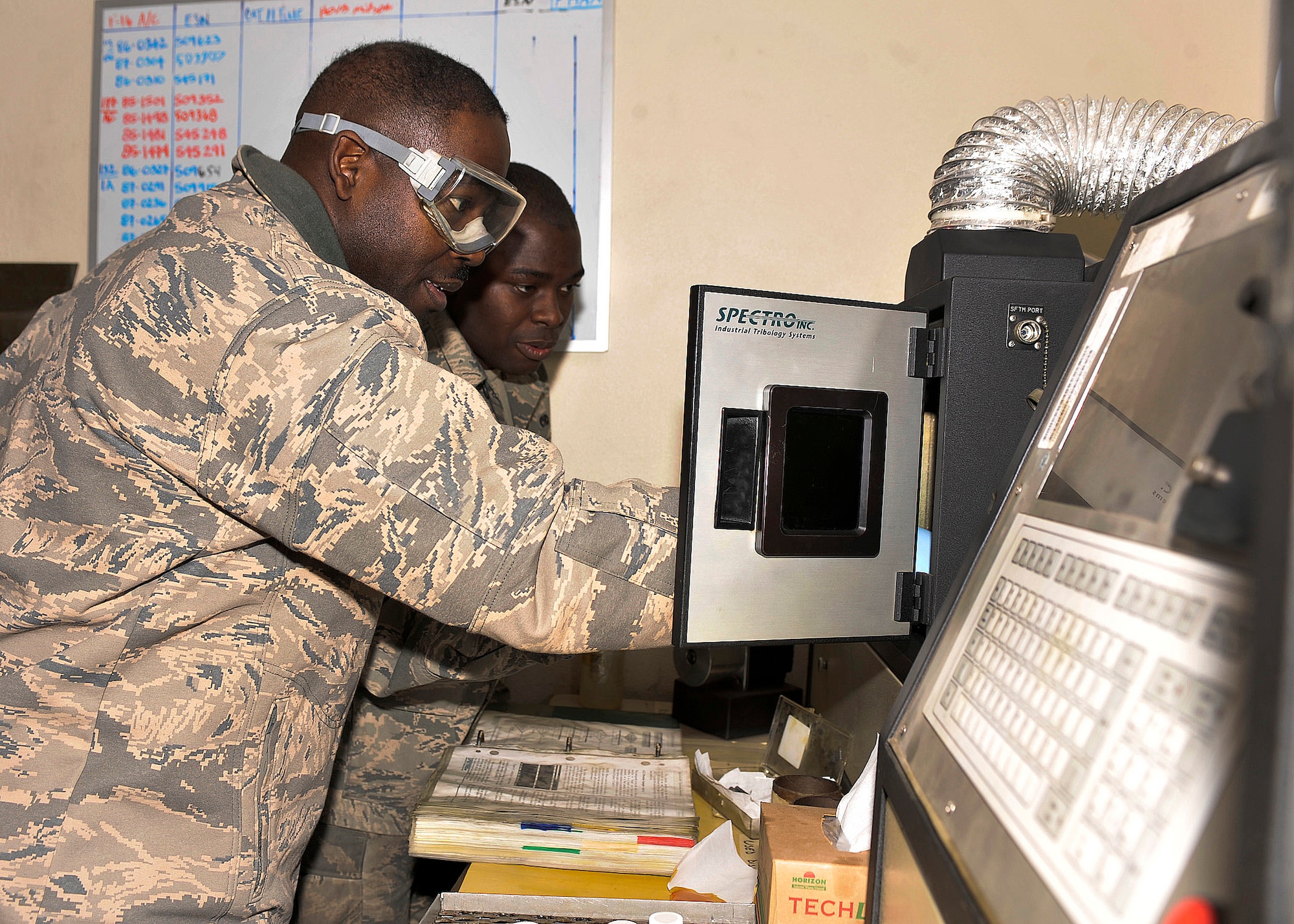BAGRAM AIRFIELD, Afghanistan— Airman 1st Class Darren Robinson assists Chief Master Sgt. Marcus Snoddy in burning jet fuel samples at Bagram Airfield, Afghanistan, Jan. 8, 2012. Snoddy is the command chief of the 455th Expeditionary Wing and Robinson is a non-destructive inspector with the 335th Aircraft Maintenance Unit. Snoddy burned jet fuel as a part of his and Maj. General Darryl Roberson morale visit to the 455th Expeditionary Maintenance Squadron. (U.S. Air Force photo/ Airman 1st Class Ericka Engblom)