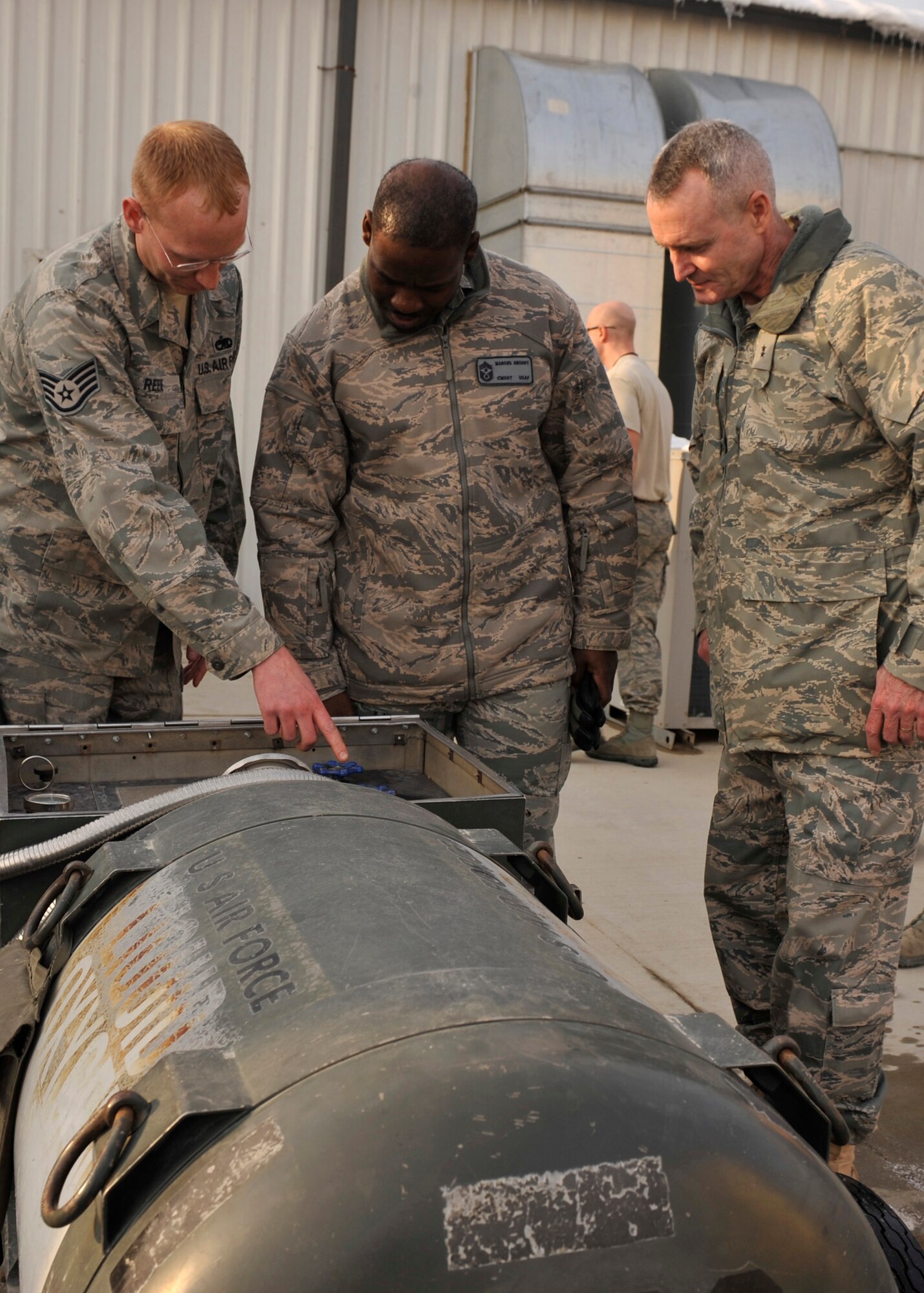 BAGRAM AIRFIELD, Afghanistan—Maj. Gen. Darryl Roberson and Chief Master Sgt. Marcus Snoddy view a piece of fueling equipment by Staff Sgt. Joshua Reese at Bagram Airfield, Afghanistan, Jan. 8, 2012. Roberson is the 455th Expeditionary Wing commander, Snoddy is the command chief of the 455th Expeditionary Wing and Reese is a shift supervisor of the Electrical and Environmental Shop with the 455th Expeditionary Maintenance Squadron. Robberson and Snoddy spoke with Reese while on a morale visit the 455th Expeditionary Maintenance Squadron. (U.S. Air Force photo/ Airman 1st Class Ericka Engblom)