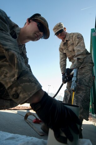 U.S. Air Force Senior Airman Kevin McDonald and Senior Airman Johnathon Copeland, 99th Civil Engineer Squadron electrical power production apprentices, perform an oil change on an Emergency Standby Generator during an annual inspection at Fire Station 3 Jan. 6, 2012, at Nellis Air Force Base, Nev. 99th CES power production Airmen, provide maintenance for over 60 generators on Nellis AFB. (U.S. Air Force photo by Staff Sgt. Christopher Hubenthal/Released)