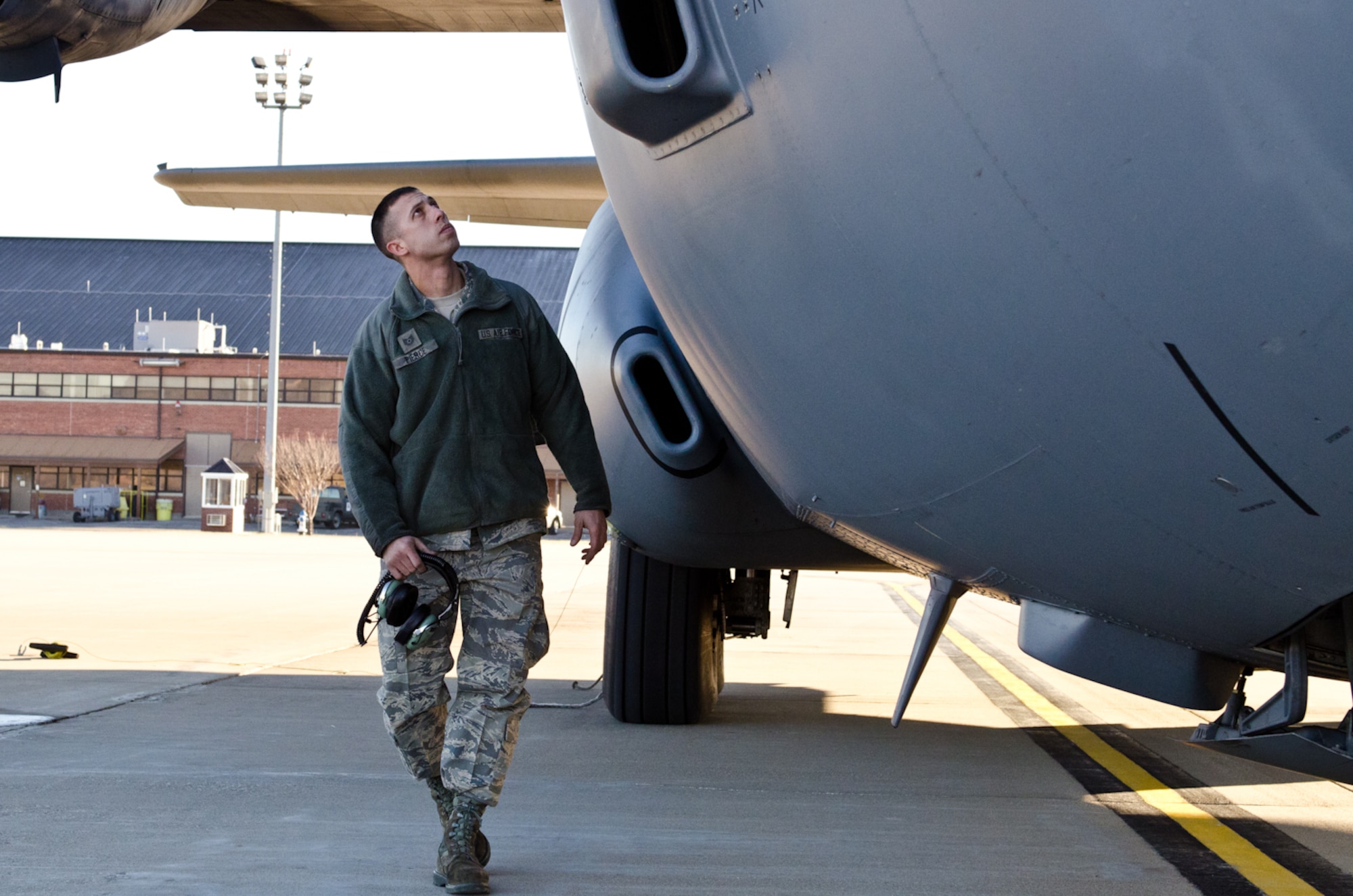 Tech. Sgt. Fred Pierce, 139th Aircraft Maintenance Squadron crew chief, walks along the fuselage of a C-130 Hercules aircraft at Rosecrans Air National Guard Base, St. Joseph, Mo., on Dec. 29, 2011. Pierce was selected as the Outstanding Noncommissioned Officer of the Year for the Missouri Air National Guard. (Missouri Air National Guard photo by Staff Sgt. Michael Crane)