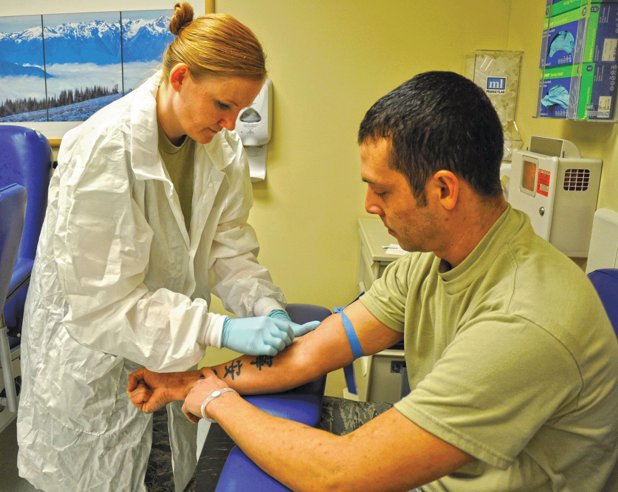 Staff Sgt. Autumn Padilla, 446th Aerospace Medicine Squadron laboratory technician out of McChord Field, Wash., tries to minimize Tech. Sgt. David Buchanan's pain while drawing his blood at the McChord Clinic here during the Reserve weekend, Jan. 8, 2012. When he isn't "dontating" blood, he works at the 446th Security Forces Squadron. (U.S. Air Force photo/Master Sgt. Jake Chappelle)