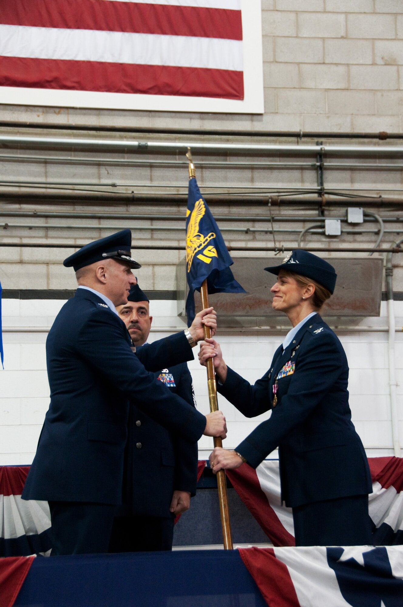 In a change of command ceremony on Otis Air National Guard Base, held on 7 January, 2012, Col. Virginia Doonan accepts command of the 102nd Intelligence Group, receiving the group's guidon from the 102nd Intelligence Wing Commander Col. Anthony Schiavi. (U.S. Air Force Photo by Master Sgt. Aaron Smith)