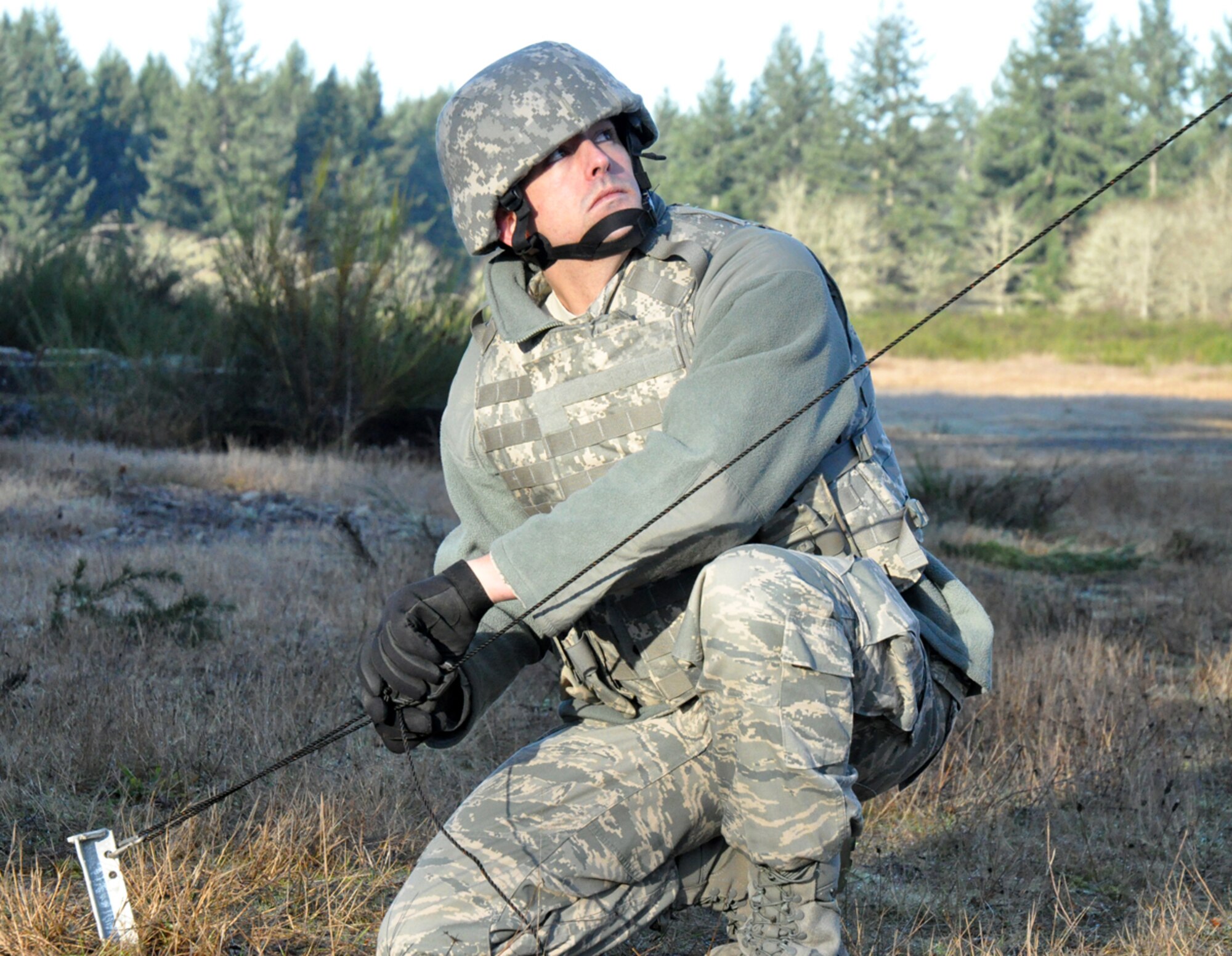 MCCHORD FIELD, Wash. -- Staff Sgt. Casey Drab, a Reservist with the 446th Security Forces Squadron, kills the slack on a hold down line for a remote communications antenna mast during a field training exercise here on Jan. 8, 2012. This type of communication device is often the first thing erected by security forces when deployed to provide a line of communication between the base defense operations center and command post. "This is a perishable skill whereby if we're not doing it on a regular basis, we're not going to be proficient," said Master Sgt. James Moran, the squadron's flight sergeant. "So this type of forward deployed training is valuable; and I like it because we have to use our team-building skills and work together."  (U.S. Air Force photo by Staff Sgt. Grant Saylor)