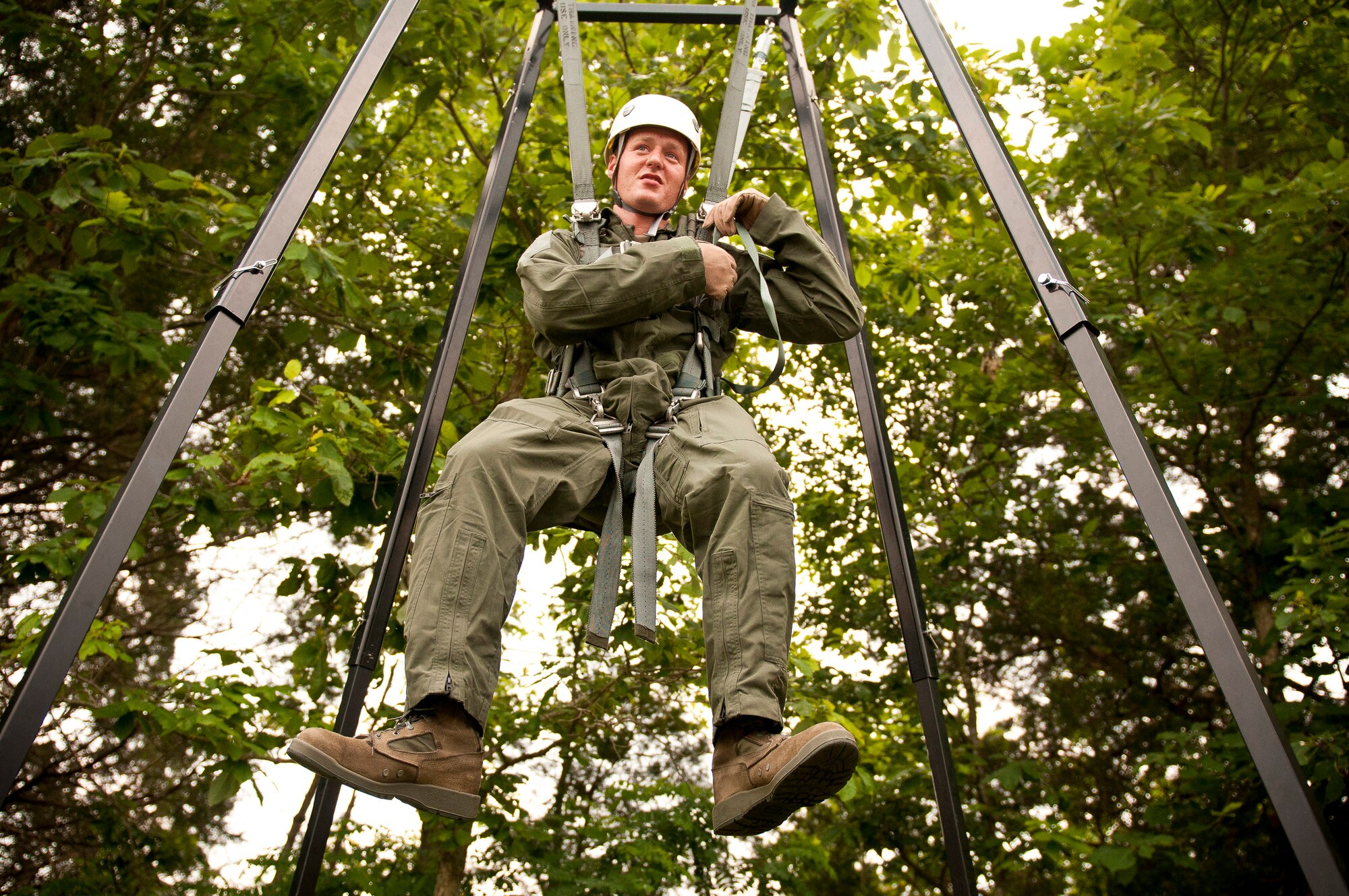 Senior Airman Micah Haddix, a loadmaster with the Kentucky Air National Guard's 165th Airlift Squadron, prepares to release himself from a parachute suspended in a training rig at Taylorsville Lake in Taylorsville, Ky., on June 9, 2011. The rig is designed to help Airmen learn how extricate themselves from trees if they become entangled after jumping from disabled aircraft. (U.S. Air Force photo by Senior Airman Maxwell Rechel)