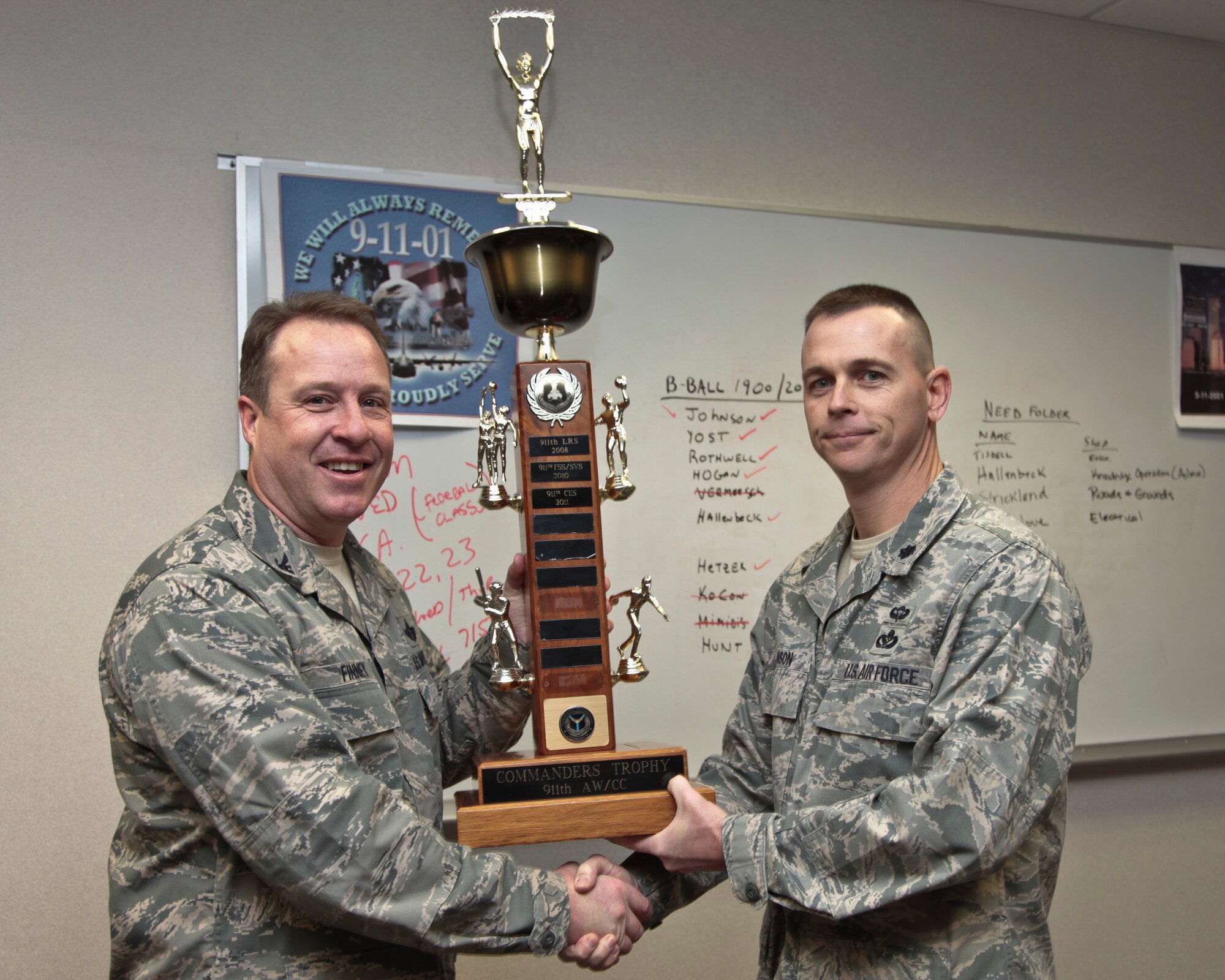 Lt. Col. Brady Johnson,right, 911th Civil Engineering Squadron commander, receives a trophy from Col. James B. Finney, 911th Airlift Wing commander, Jan. 7 2012. Johnson received the trophy for succesfully  winning the Civil Engineering Squadron intramural sports championship. (US  Air Force photo by Senior Airman Joshua J. Seybert/Released)