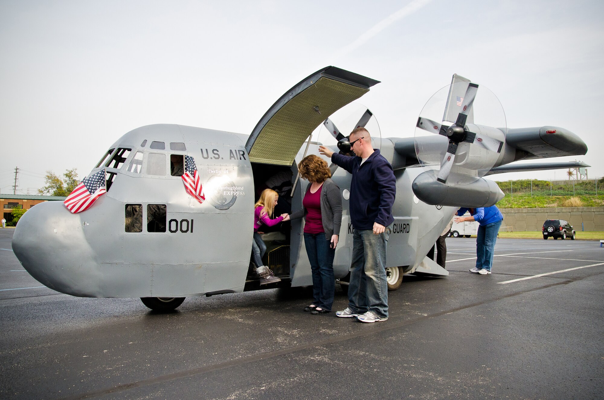 Family members of Kentucky Air Guardsmen exit the 123rd Airlift Wing's Mini C-130 after an orientation "flight" Oct. 23, 2011, during the wing's annual Family Day celebration in Louisville, Ky. The Mini C-130 is a scale replica of the Hercules transport aircraft, built on a golf-cart chassis and propelled by a 27-horsepower gasoline motor. Although incapable of flight, it can reach speeds of up to 20 mph, features working propellers, a functional cargo door, a UHF radio, a high-powered stereo system and seating for up to a dozen passengers. The replica was built from scratch by the Airmen of the Kentucky Air Guard's 123rd Maintenance Squadron. (U.S. Air Force by Maj. Dale Greer)