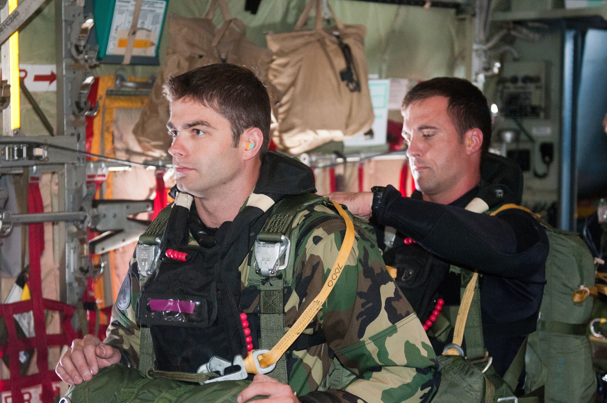 Master Sgt. Corey Kuttie (right), an active-duty pararescueman from Moody Air Force Base, Ga., inspects a parachute for Staff Sgt. Travis Brown of the 123rd Special Tactics Squadron prior to their jump from a Kentucky Air Guard C-130 on June 19, 2011. The training was part of a three-week Precision Jumpmaster Course taught by Guardsmen from the squadron. (U.S. Air Force photo by Master Sgt. Phil Speck)