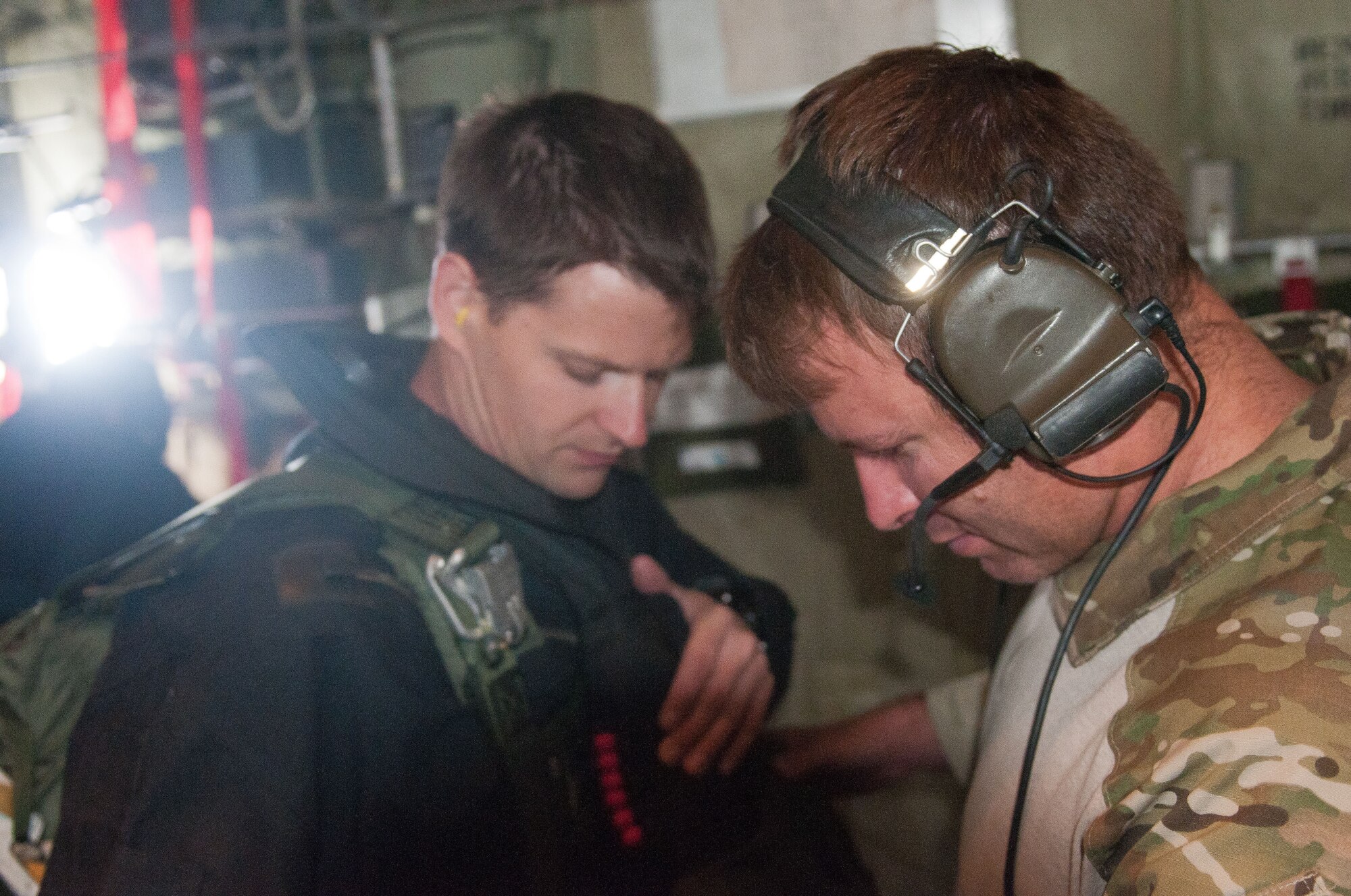 Master Sgt. Ed McKenna (right), a pararescueman and instructor for the Kentucky Air Guard’s Precision Jumpmaster Course, checks out the parachute gear of Senior Airman Ryan Belew, a fellow 123rd Special Tactics Squadron pararescueman, as Belew prepares to jump from a C-130 aircraft June 19, 2011, at Lake St. Clair, Mich. The course was designed to provide instruction in the skills needed to rescue anyone on land or water. (U.S. Air Force photo by Master Sgt. Phil Speck)