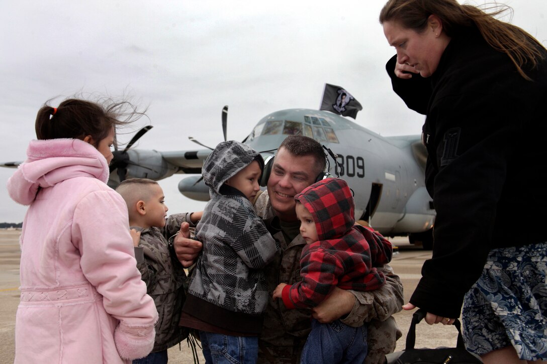 Staff Sgt. Matthew Wallfred, quality assurance chief for Marine Aerial Refueler Squadron 252 detachment attached to 22nd Marine Expeditionary Unit, hugs his family after returning to Marine Corps Air Station Cherry Point January 9, after an eight-month deployment to Sicily, Italy and Djibouti. "It's always hard to be away for the holidays," said Wallfred, "but it's one of those things that come with the job."