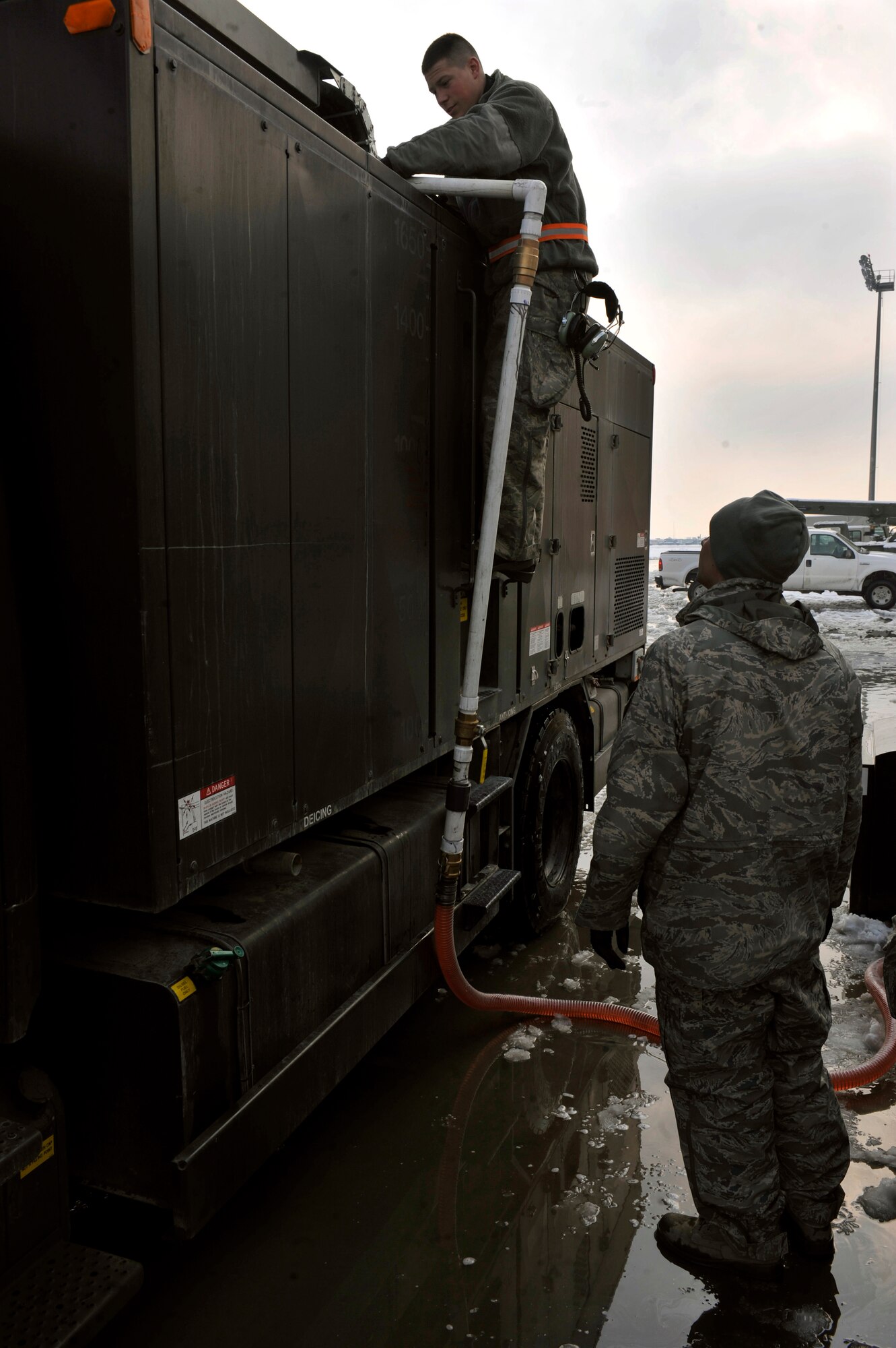BAGRAM AIRFIELD, Afghanistan—Staff Sgt. Chase Dowd and Staff Sgt. Mike Dereu refill their de-icing truck at Bagram Airfield, Afghanistan, Jan. 5, 2012.  Dowd and Dereu are in the 455th Expeditionary Aircraft Maintenance Squadron.  The truck was filled at a de-icing station constructed by the 455th Expeditionary Civil Engineering Squadron.  (U.S. Air Force photo/Airman 1st Class Ericka Engblom)
