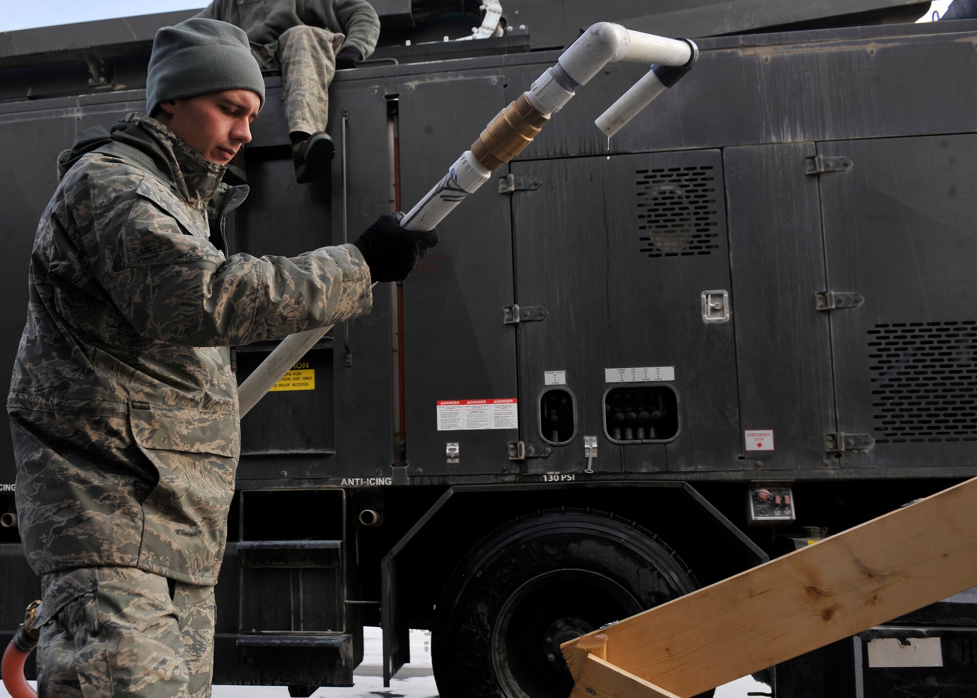 BAGRAM AIRFIELD, Afghanistan—Staff Sgt. Chase Dowd reattaches a makeshift hose to a temporary de-icing station constructed at Bagram Airfield, Afghanistan, Jan. 5, 2012.  Dowd is in the 455th Expeditionary Aircraft Maintenance Squadron.  He used the station to refill his 2,450 gallon truck with pre-mixed solution within 20 minutes, as opposed to the average three hours it would take without a station.  (U.S. Air Force photo/Airman 1st Class Ericka Engblom)