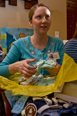 Allison Hailstone, wife of Senior Airman Tyler Hailstone, 99th Civil Engineer Squadron heating, ventilation and air conditioning journeyman, opens presents during the Operation Showers of Appreciation at the Nellis Family Housing Community Center Jan. 7, 2012, at Nellis Air Force Base, Nev. The military baby shower is the first of many that members of Operation Showers of Appreciation is planning to hold throughout the country for 2012. (U.S. Air Force photo by Airman 1st Class Daniel Hughes/Released)